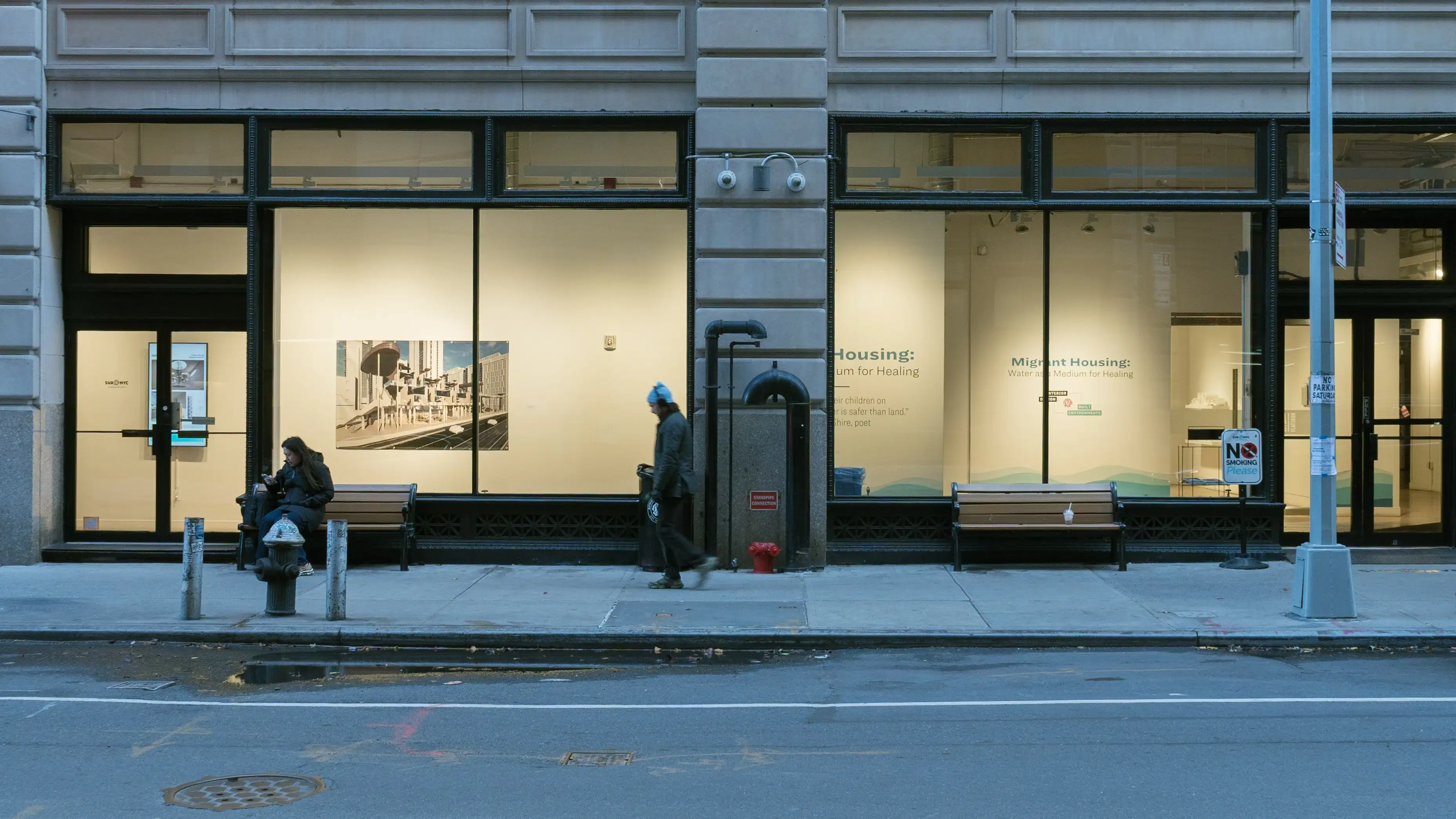 Exterior view of the SVA Flatiron Windows, with artwork displayed behind oversized windows on a wall. 