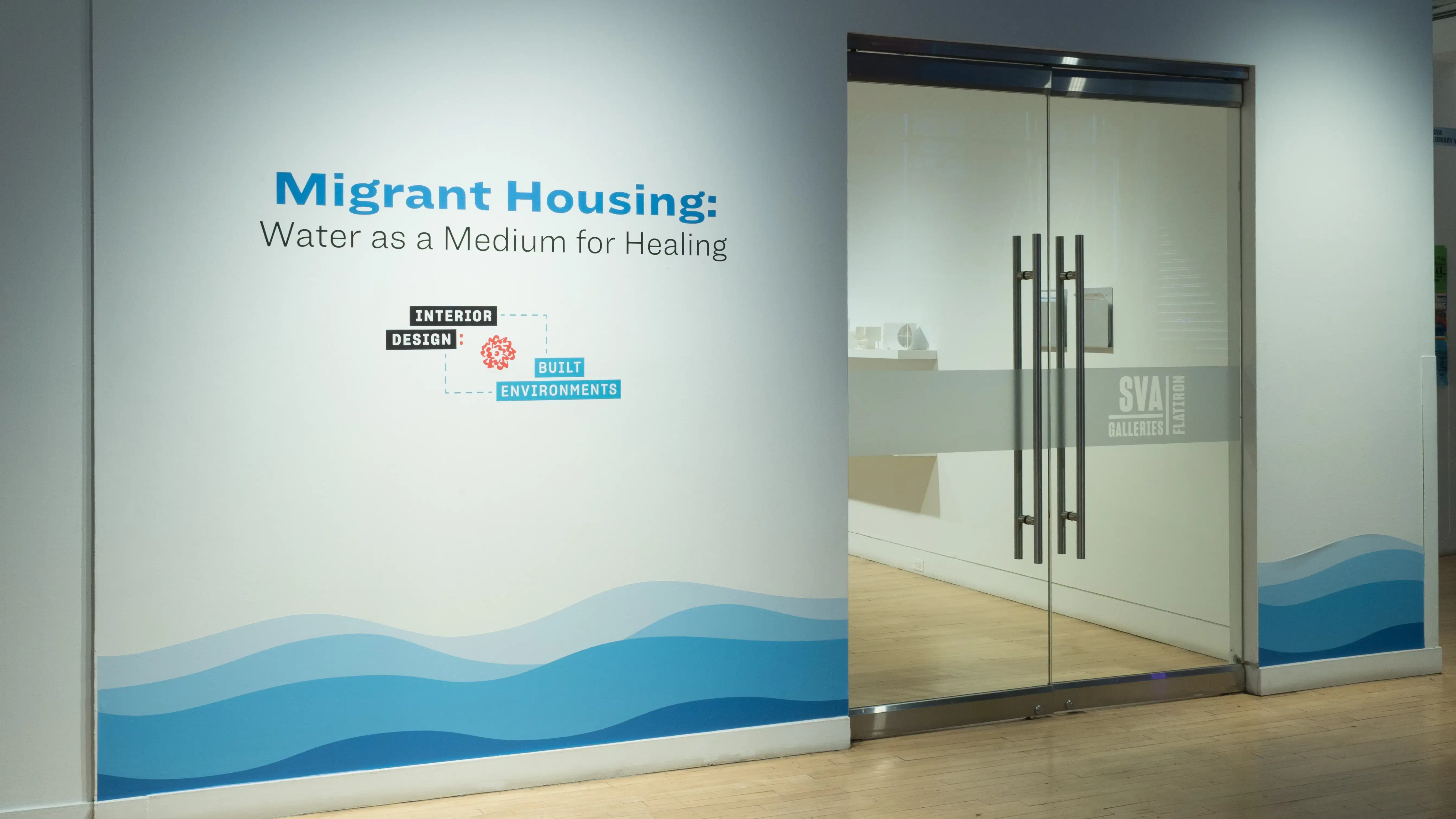 Exterior of gallery space showing the exhibition's title with a stylized graphic of water along the bottom border of the wall. 