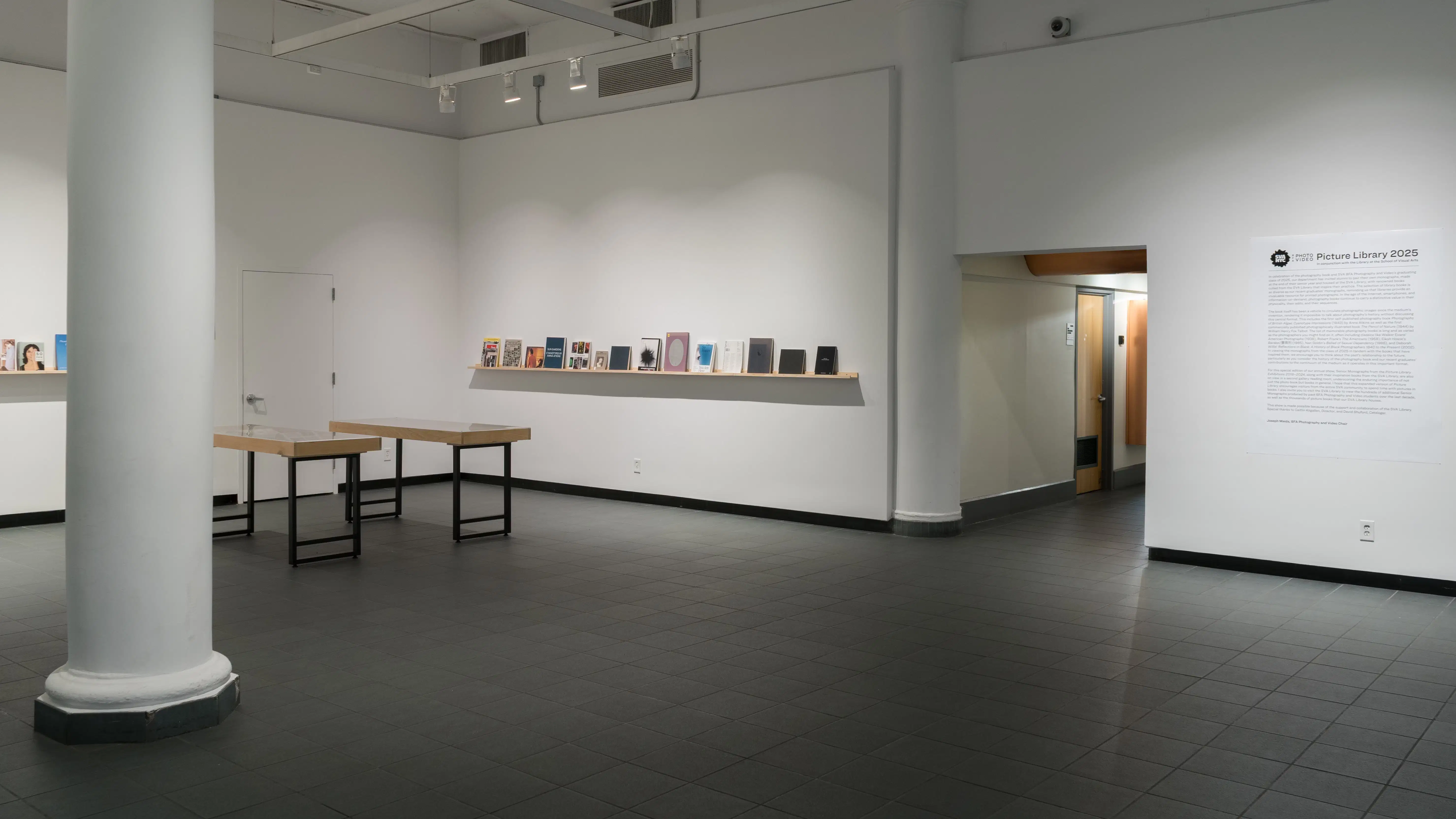 Entering the SVA Gramercy Gallery, vitrines and shelves of books are visible to the left. Straight ahead, a wall of text reads “Picture Library 2025” with further explanation.