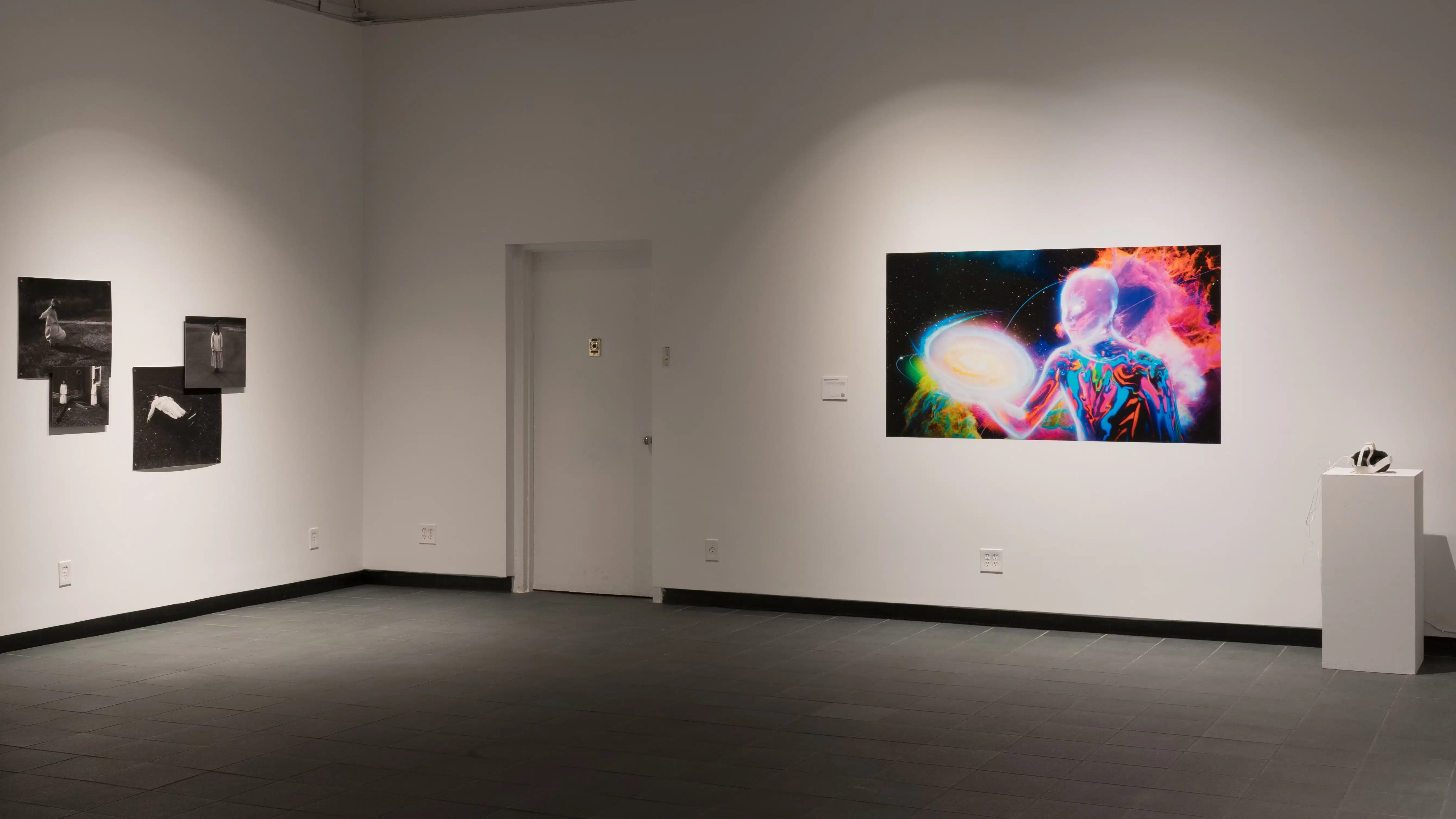 On the right wall, a brightly colored image of a figure holds a planet, with four dark photographs pinned on the wall to the left.