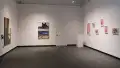 Looking into the SVA Gramercy Gallery, on the left wall is an image with headphones, on the far center wall are two framed photos with text beside it, and on the right are six photos hung apart.
