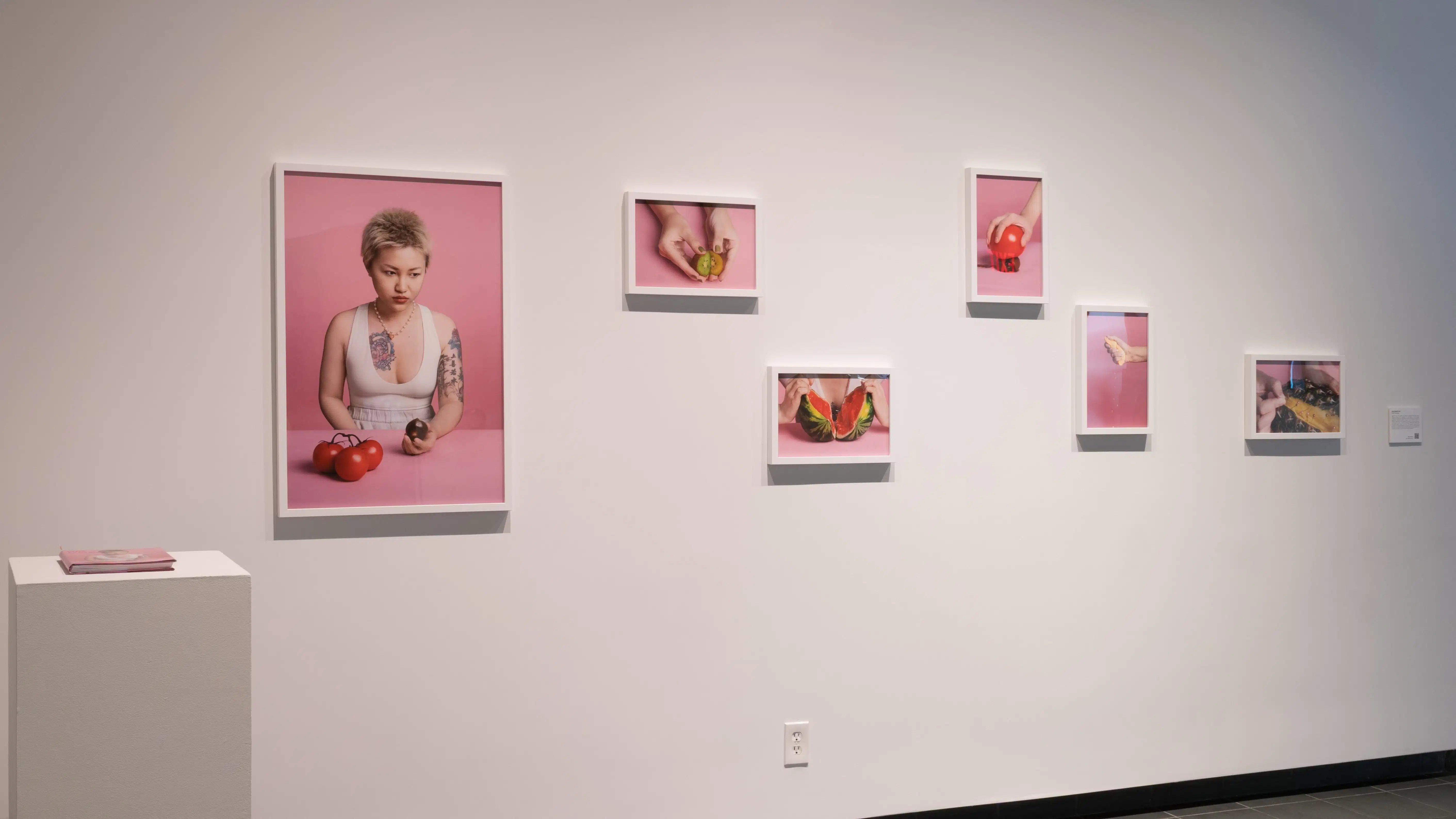 Six photos, one of which is a figure holding vegetables, and the others of which are close-ups of fruit. On the left beside it is a pillar with a book.