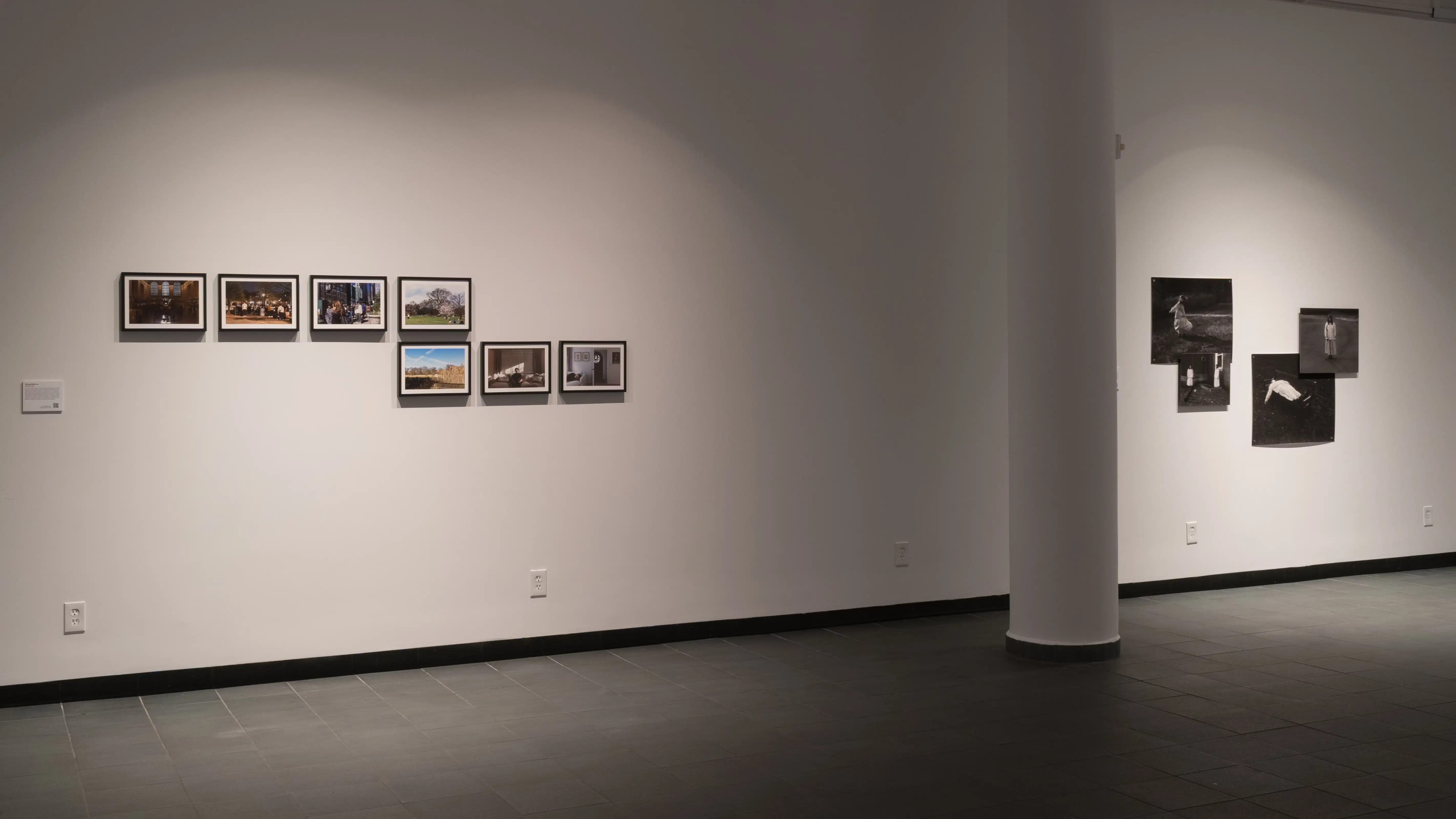 A wall with seven small photographs lined on the left, and four photos pinned to the right, with a structural pillar in between.