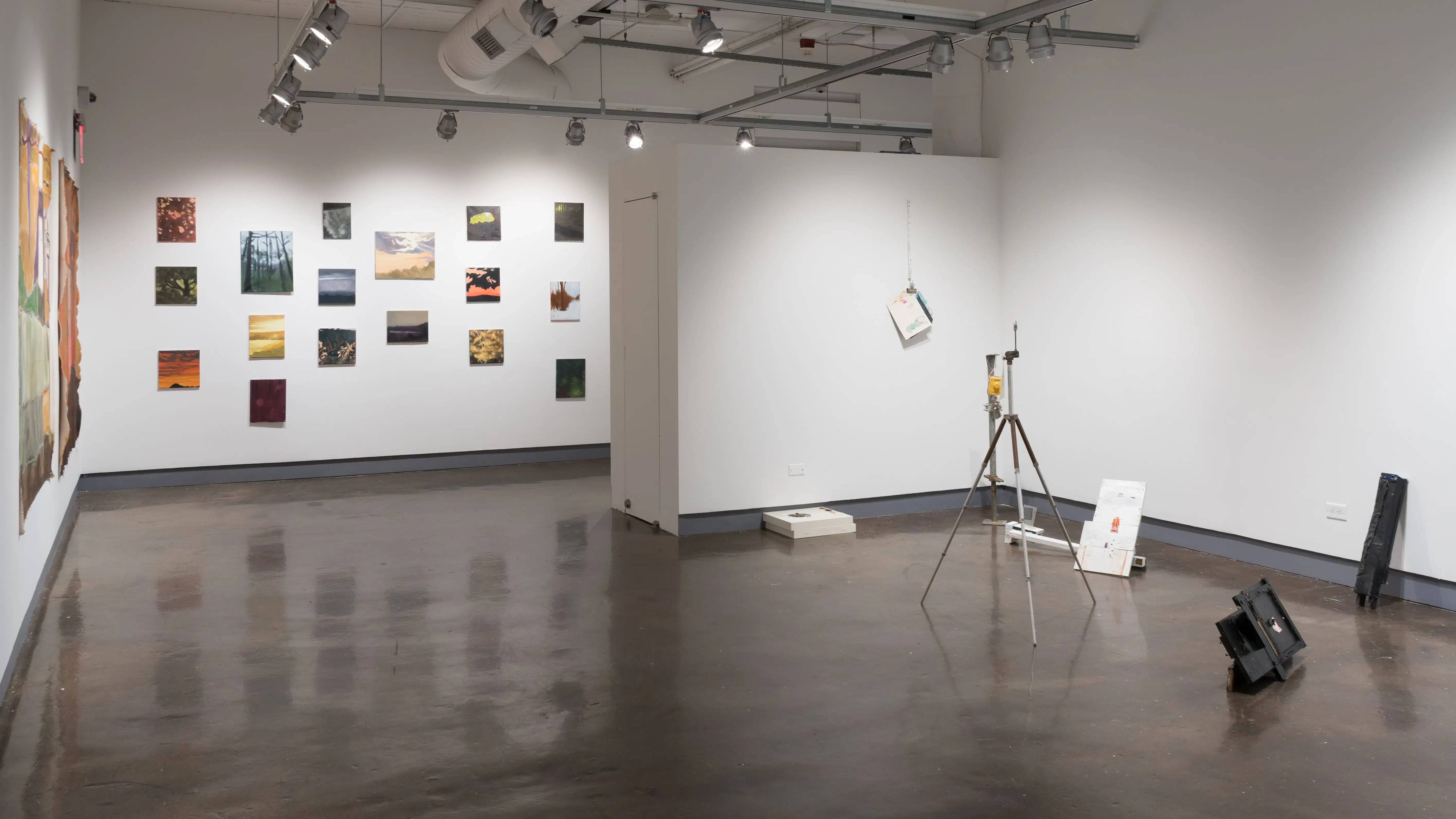 A corner in the fourth gallery with several small paintings on the far wall, and mixed media sculptures on the right.