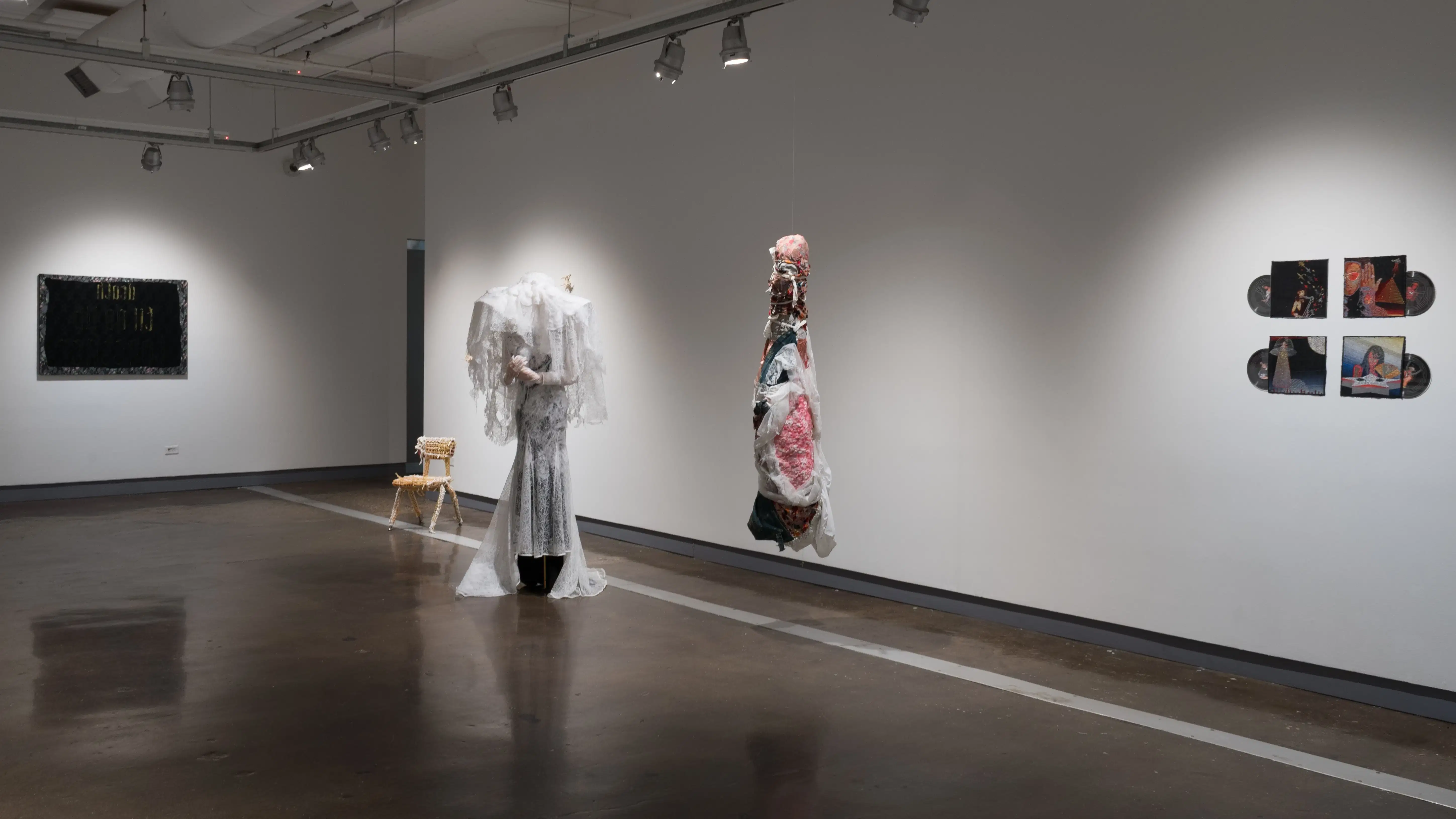 Installations within the second gallery, including a veiled mannequin and sculpture that looks like a wrapped corpse are displayed.