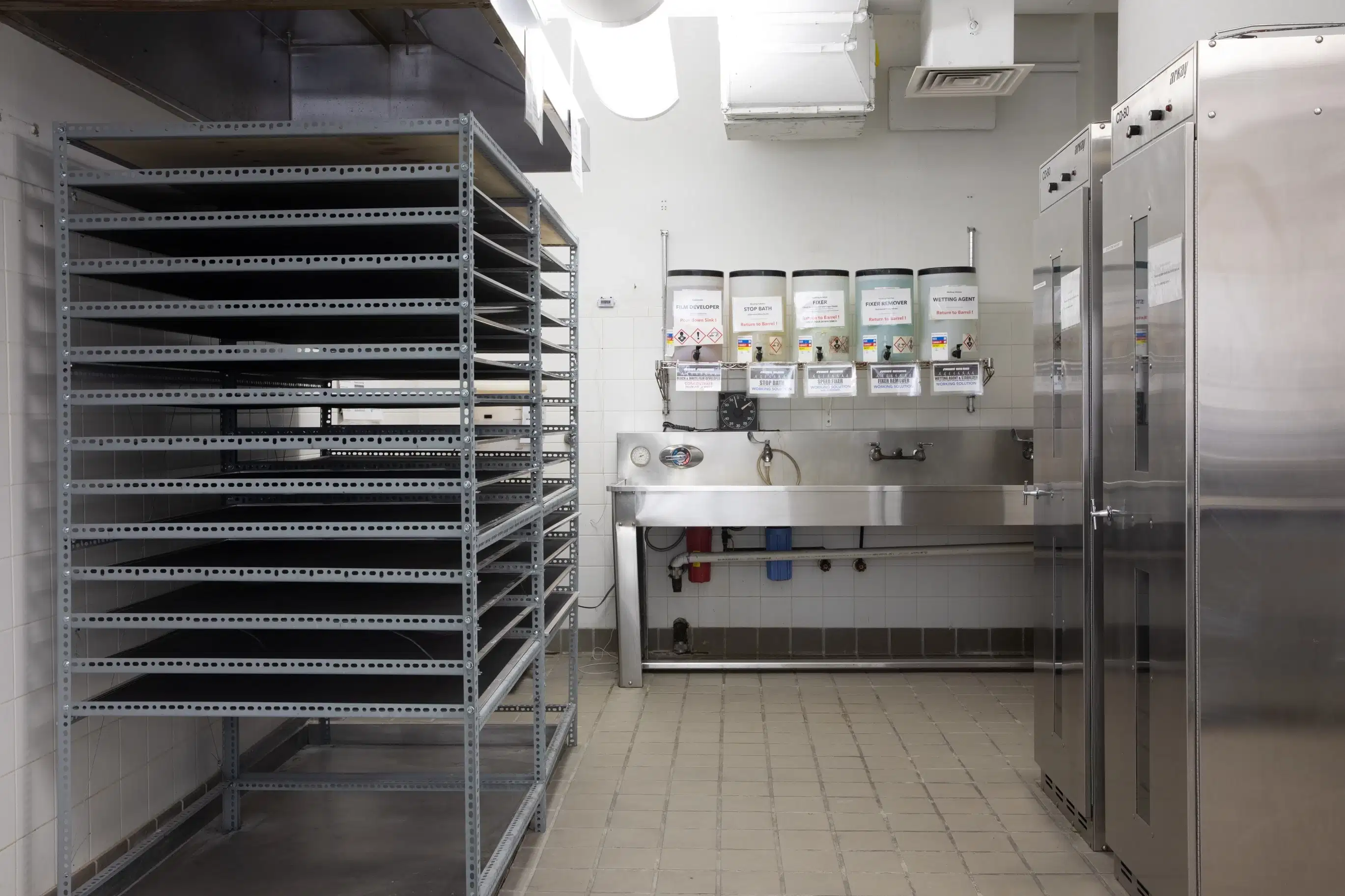 A drying rack in front of sinks.