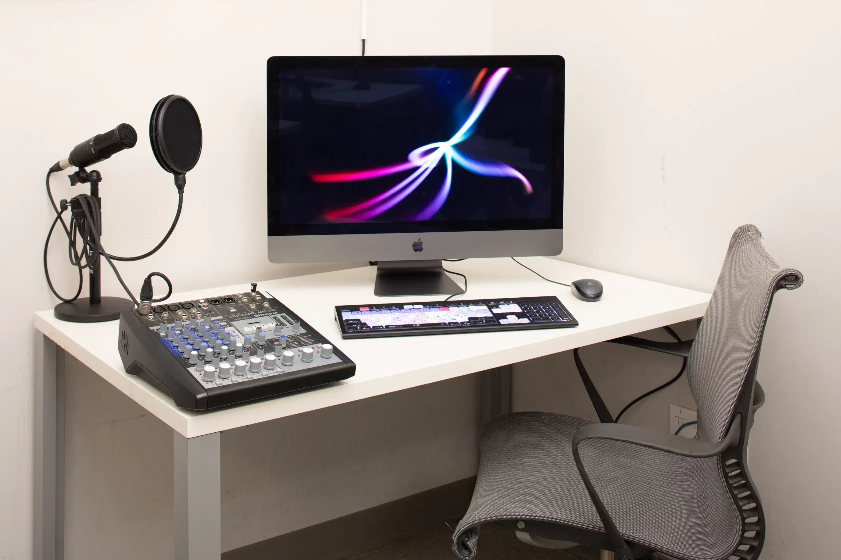 A digital work station with a monitor, mixing board, and mic