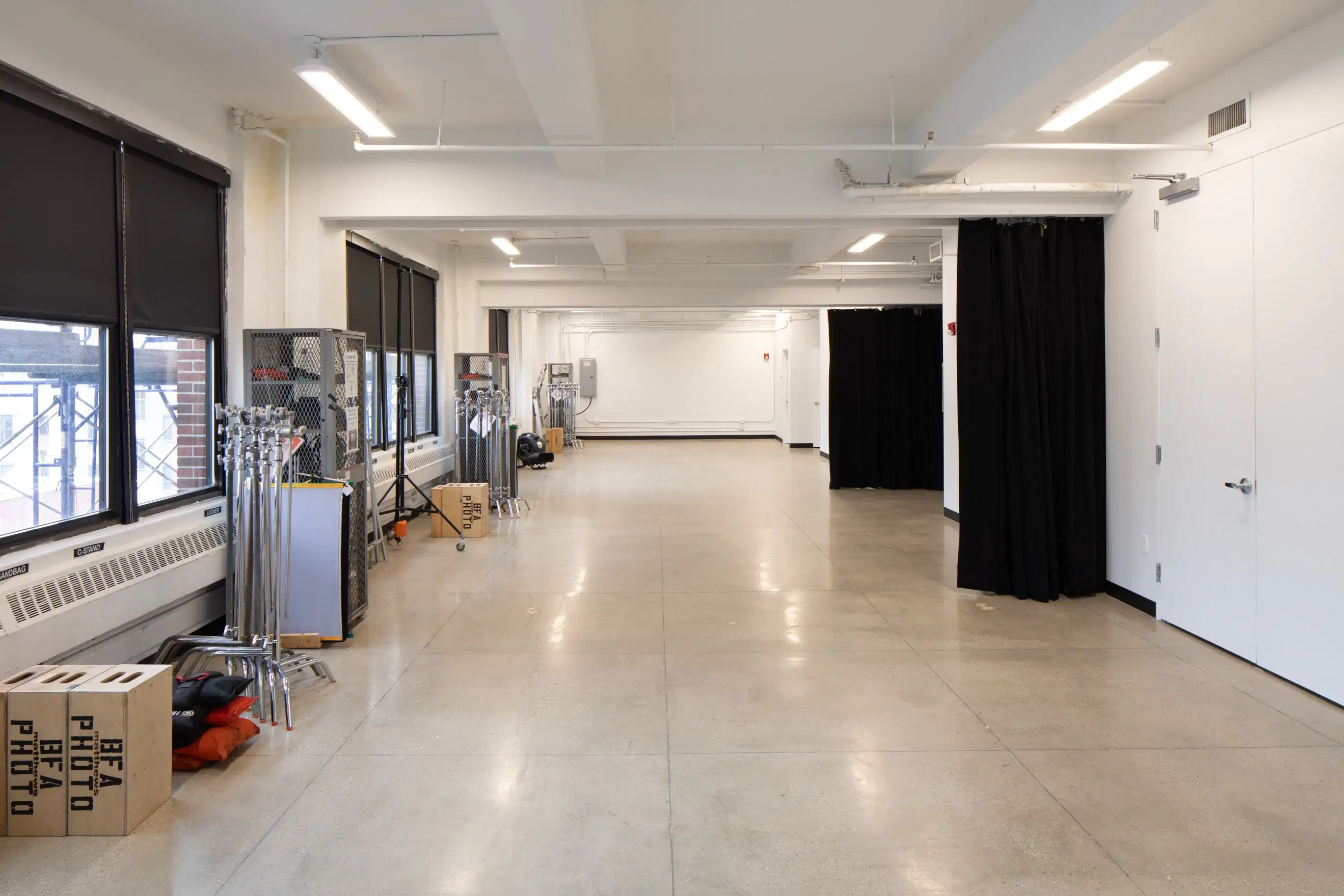 Large photo studio with windows and equipment on the left