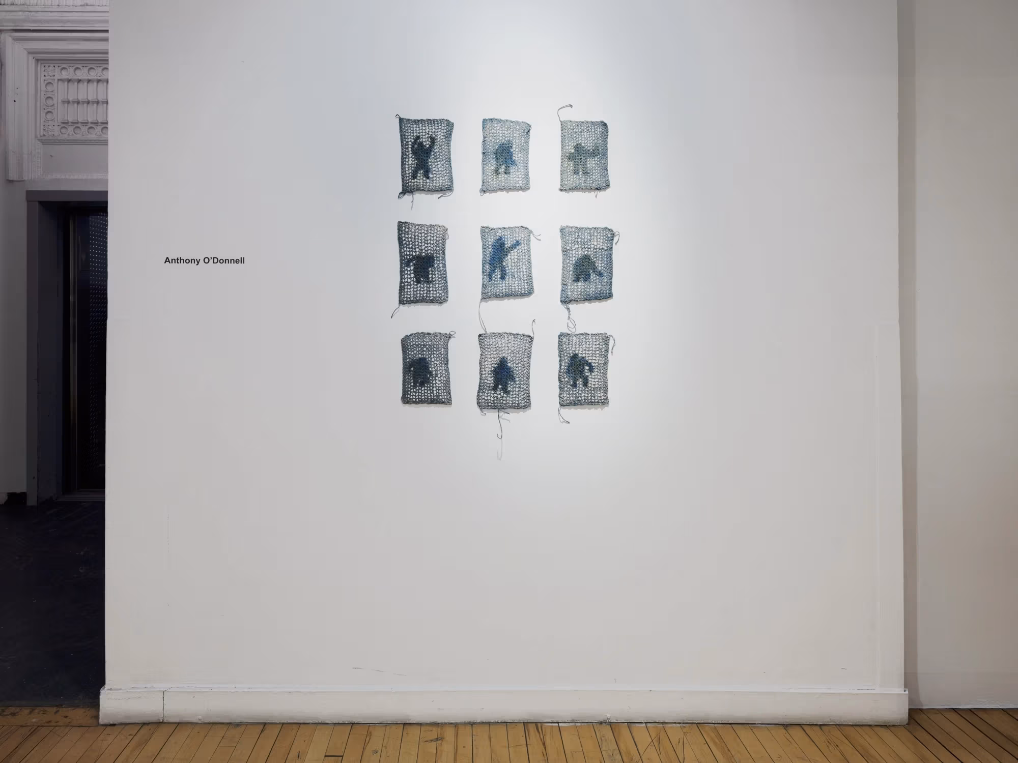 Nine woven artworks hung in a grid.