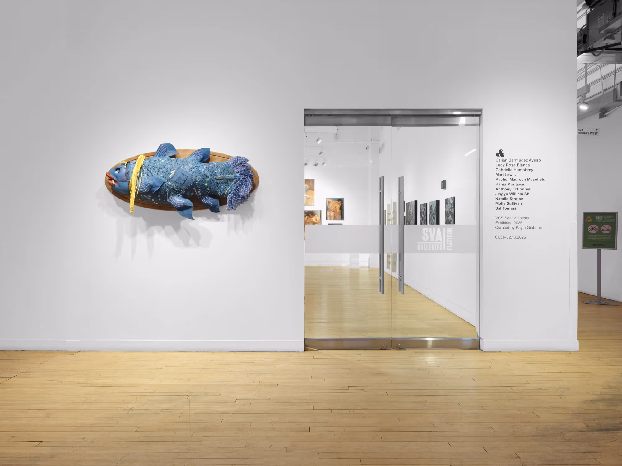 The door of the gallery space with a sculptural piece resembling a fish to the left of the door.