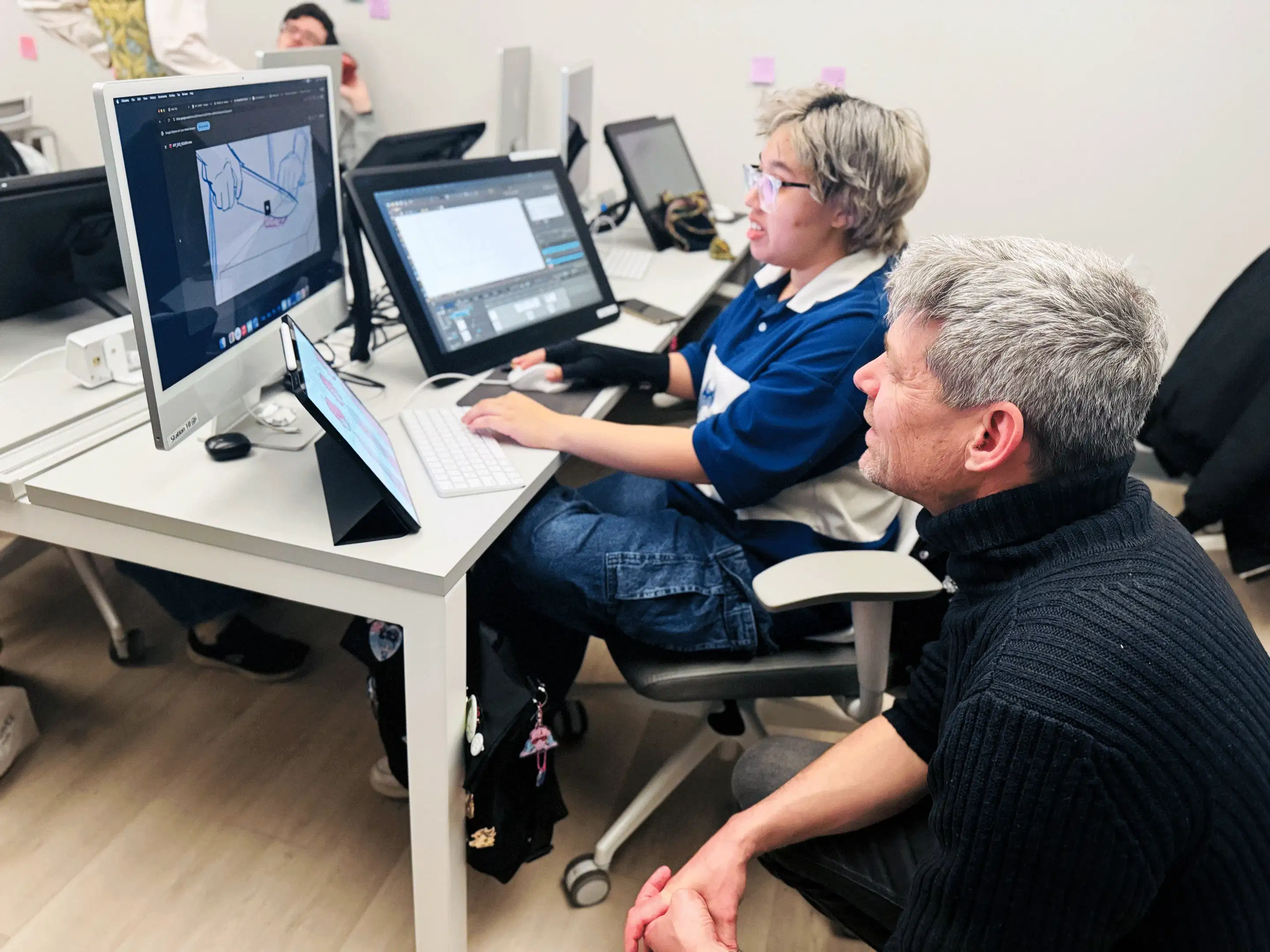 [Left]:Four individuals are standing underneath a neon sign "Animation First." [Middle]:Two Individuals pose in front of a miniature building set design. [Right]: One individual sits at a computer desk as a second individual crouches beside them, observing the monitor.
