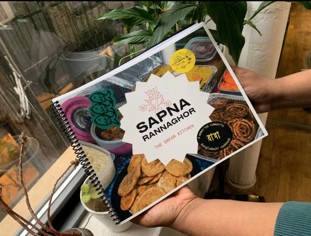 Hands holding colorful cookbook