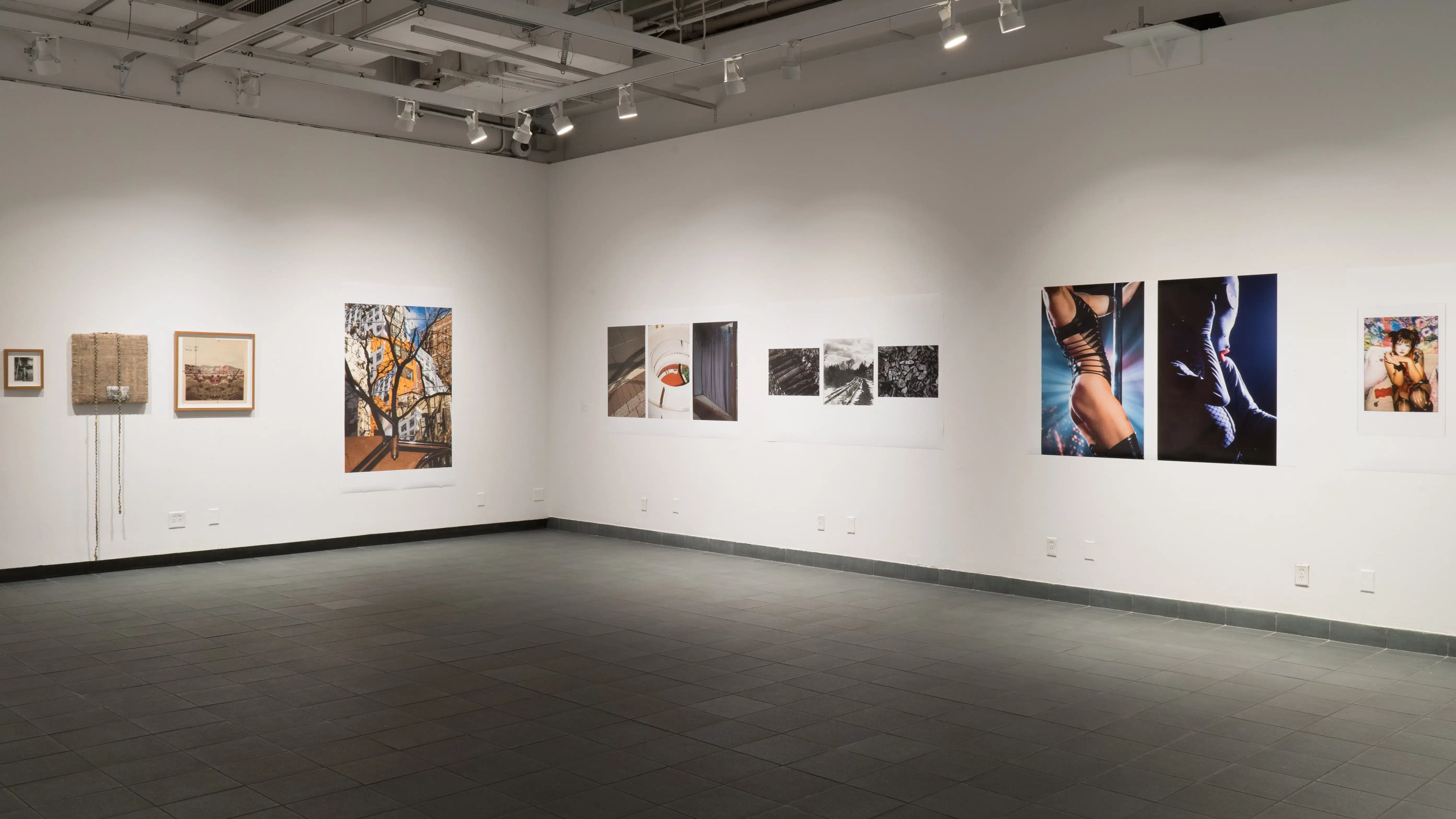An angled view of the back gallery at Gramercy gallery, showing multiple large prints and framed works on the walls.