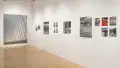 Angled shot of one wall in the Flatiron Gallery, showing multiple prints of industrial moments in varying sizes lining the walls, and an extra large print in grey on the back wall.
