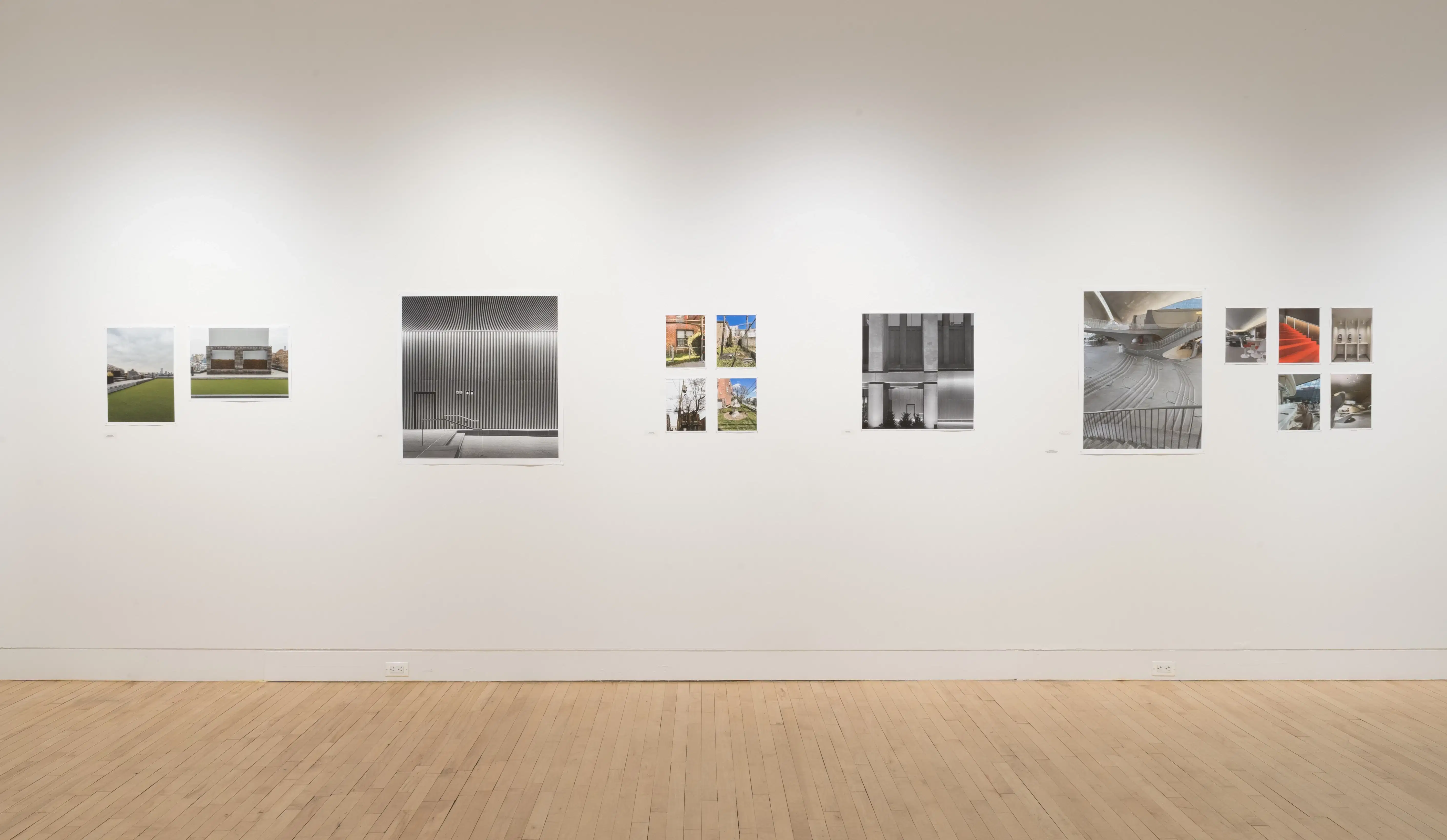 Straight shot of one wall in the Flatiron Gallery, showing multiple prints of industrial moments in varying sizes lining the walls, and an extra large print in grey on the right.