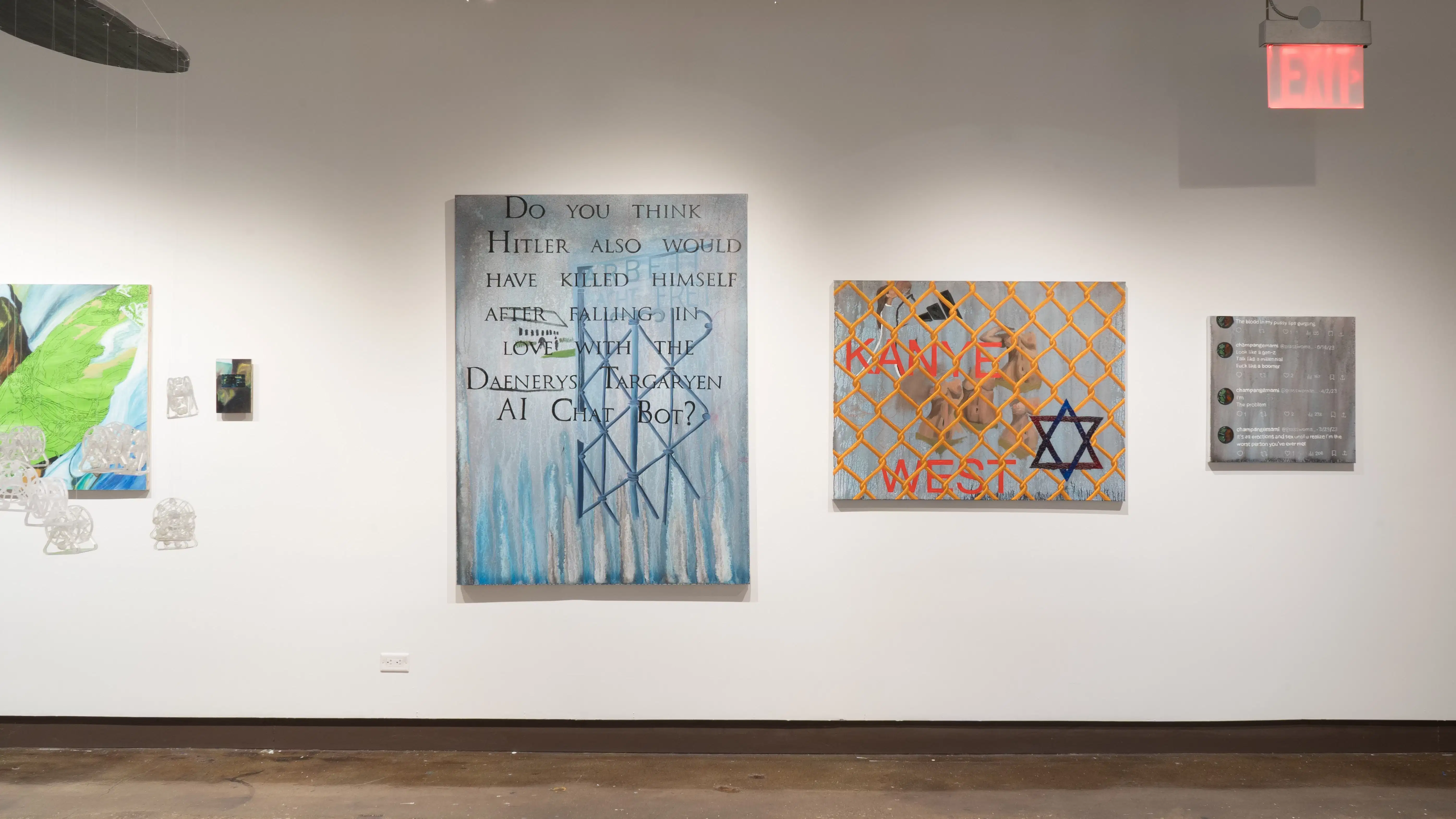 Three paintings are hung in a row, decreasing in size from left to right. They all use faded grays, text, and symbols. The center painting reads “KANYE WEST” and contains a Star of David.