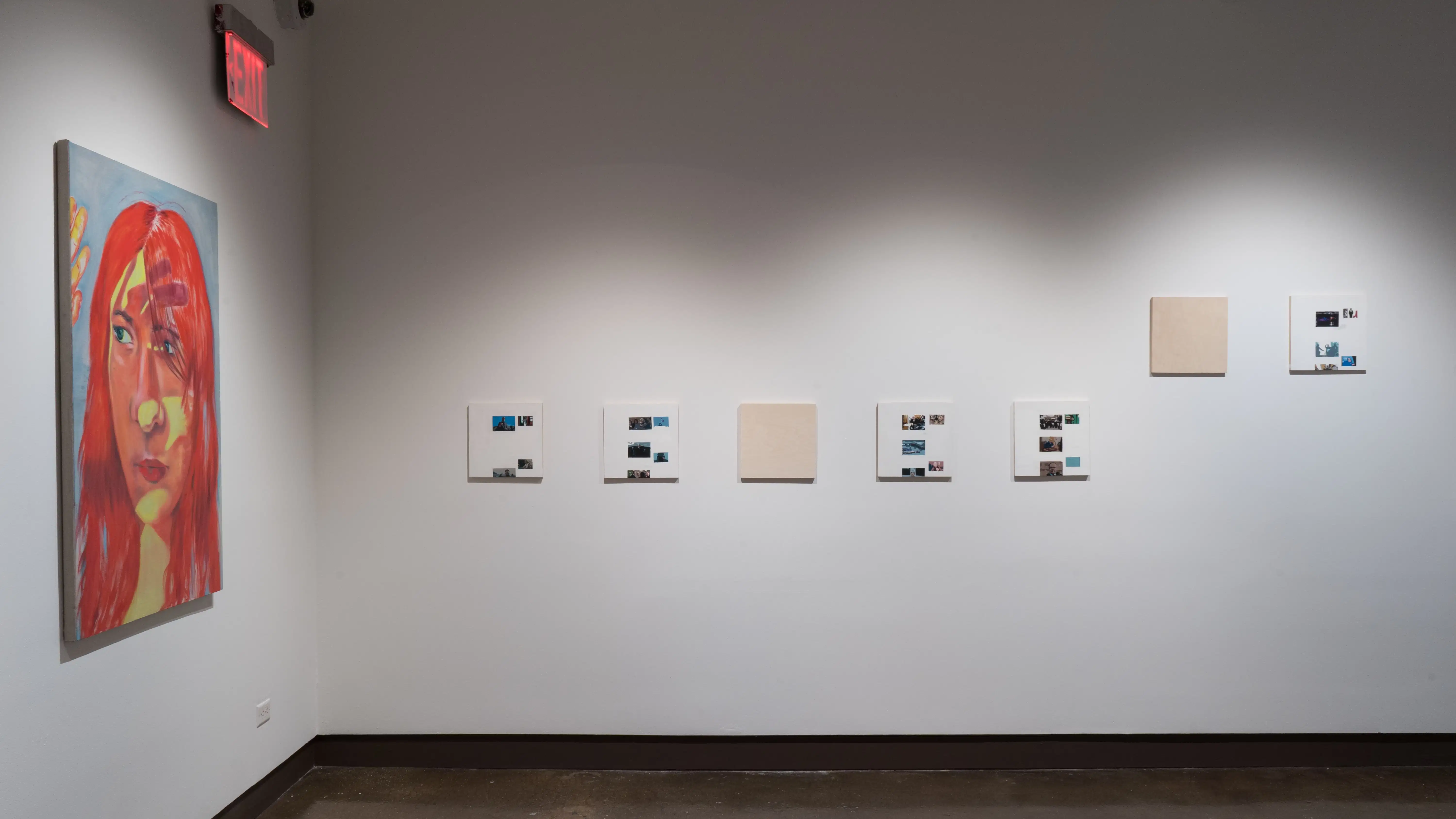 In one corner, a portrait of a woman holding her hand up to block light from her eyes is painted in bright red and yellow. To the right of the painting, several small wood panels are organized in rows.
