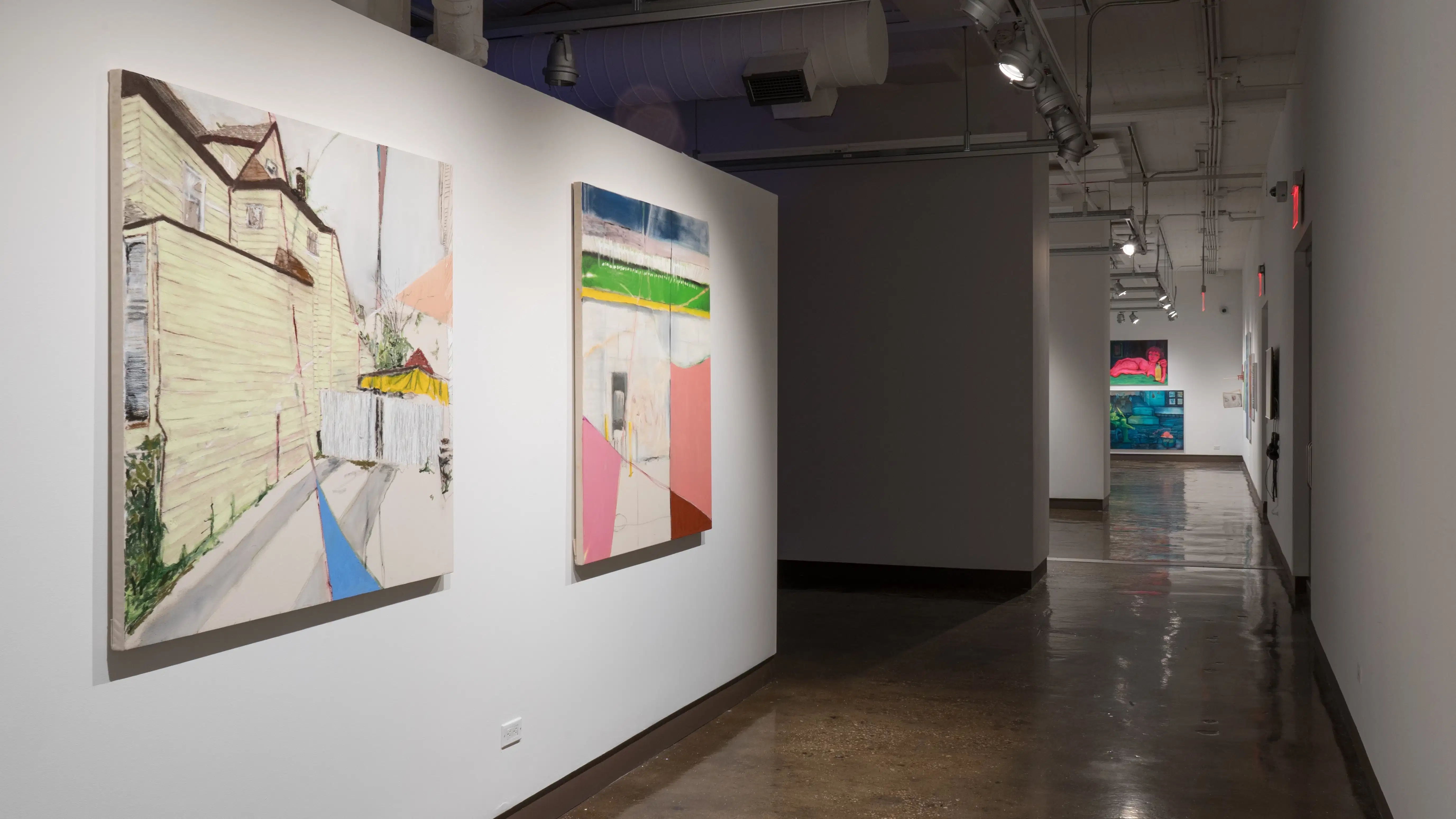 Looking down the gallery’s left hallway, there are two large paintings of exterior and interior environments beside each other. At the end of the hallway, paintings in gallery one are visible.