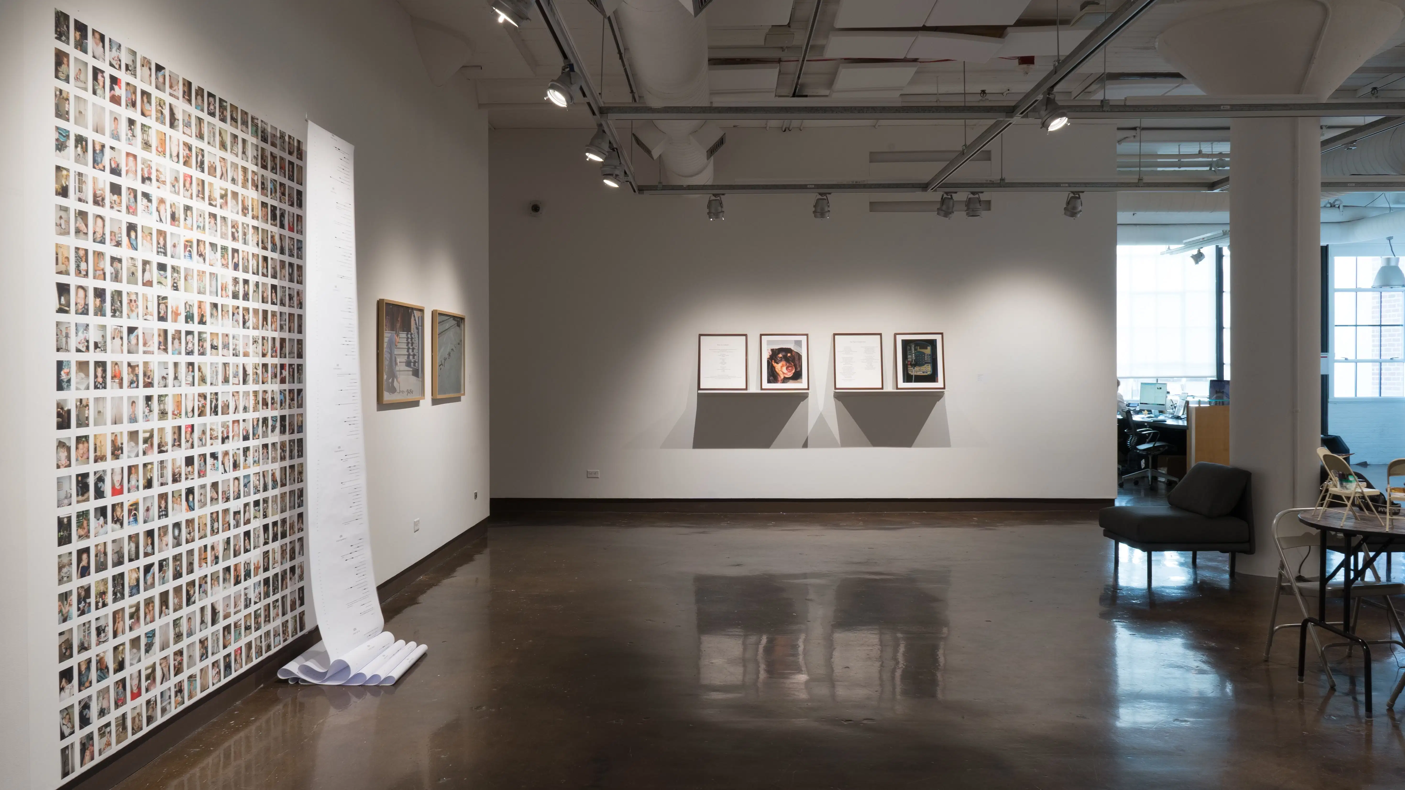 Two leveled shelves in close proximity, each featuring framed word documents on the left and print photography on the right. Angled view of print photography on left wall. 