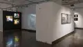 View of gallery three and hallway leading up to gallery four. Three colorful light box photographs of editorial scenes featured on gallery 3 wall. In the hallway are two large scale nightlife photographs. 