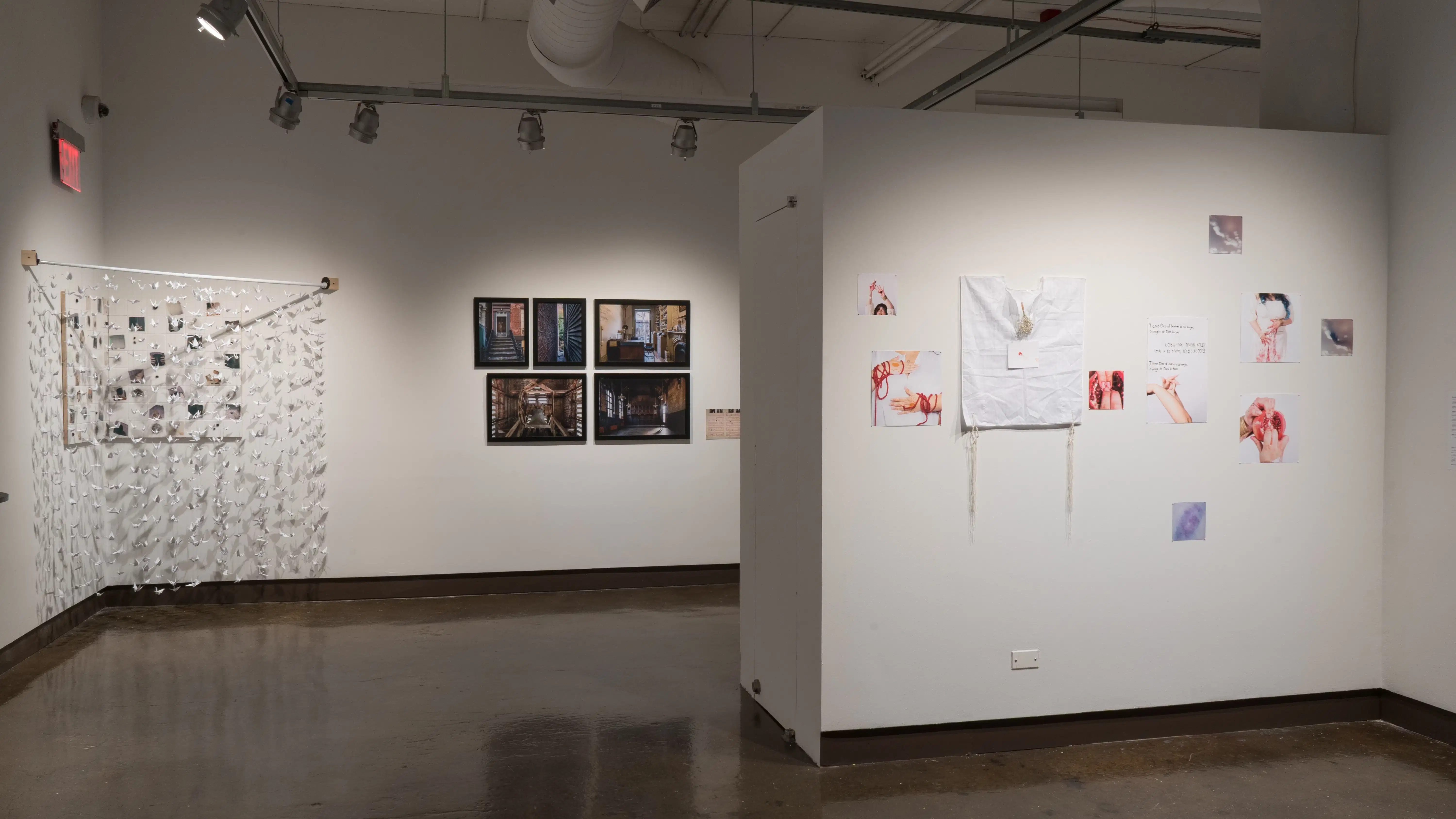 In the gallery four alcoves are dispersed small scale photography prints with found objects on the wall. Further down is urban architecture stills in black frames, in the corner is hanging paper cranes covering small scale photographs. 