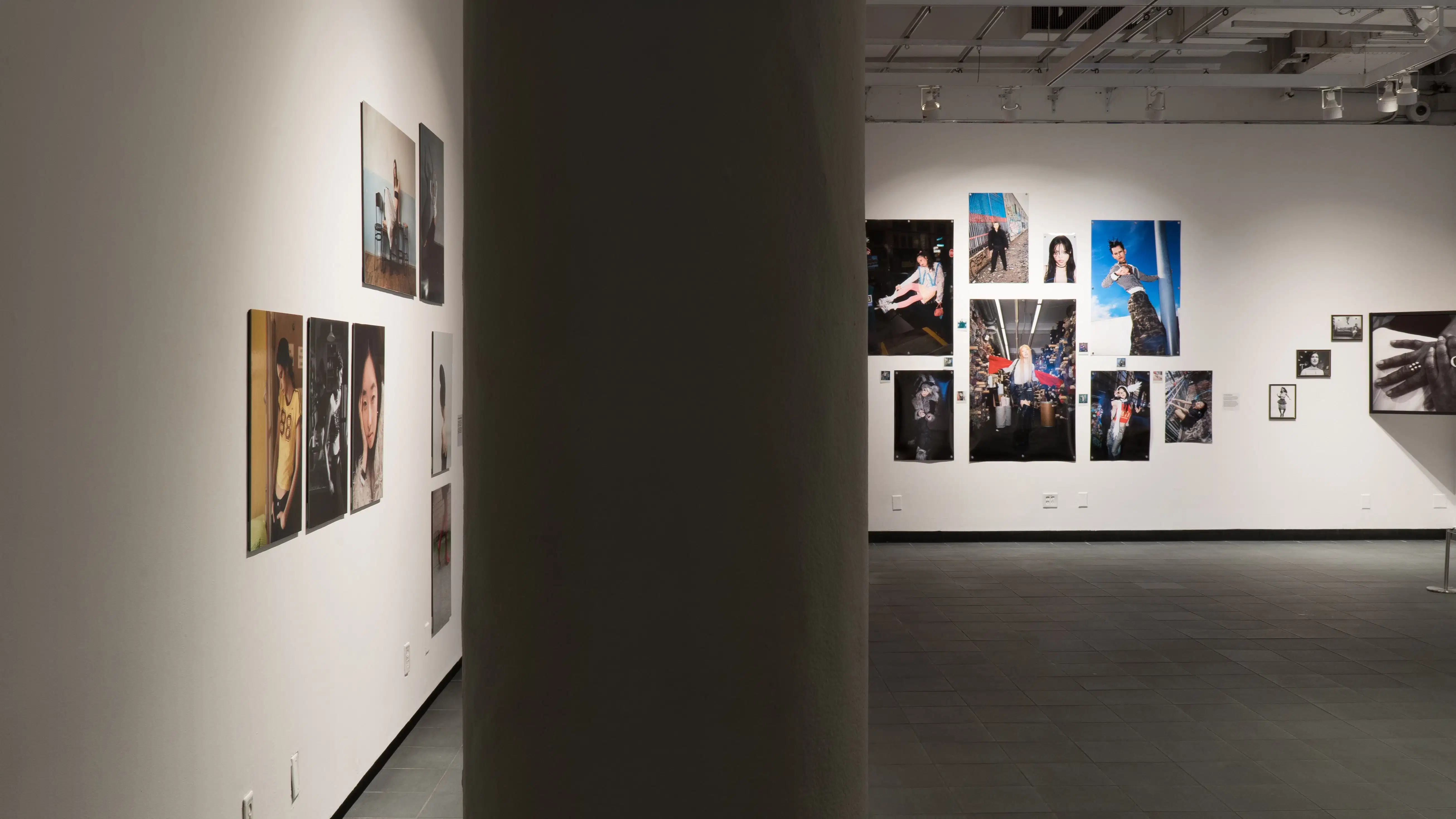 The entrance to the SVA Gramercy Gallery partially obscured by a pillar. Behind it are works of fashion photography.