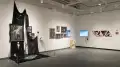 Several works on display in the SVA Gramercy Gallery, including a gothic looking one, images of a model in church, and images of men in triangular pink frames.