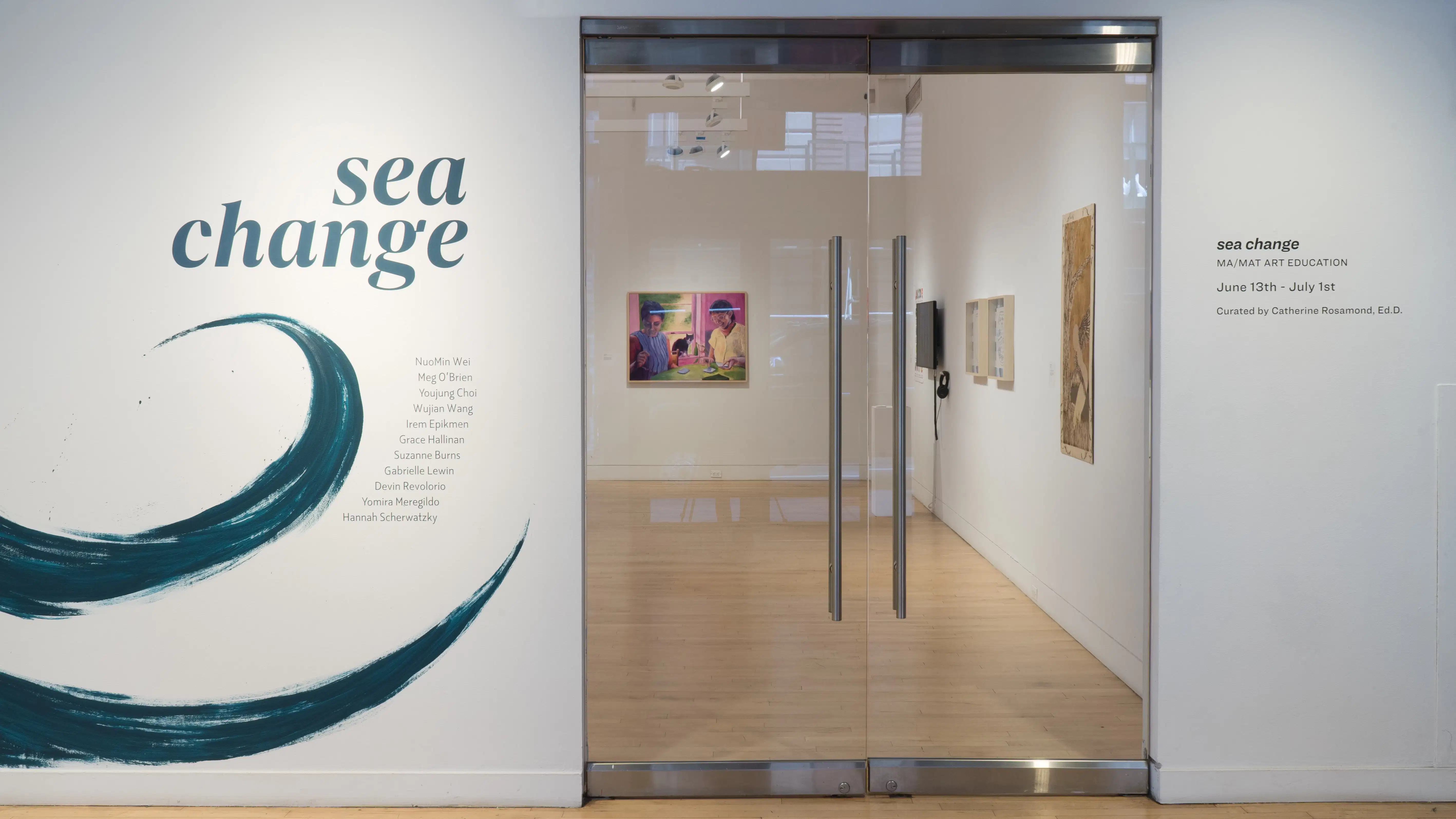 View of the doors at the SVA Flatiron Gallery featuring a painted wall with a wave and the words “sea change” to the left.