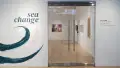 View of the doors at the SVA Flatiron Gallery featuring a painted wall with a wave and the words “sea change” to the left.