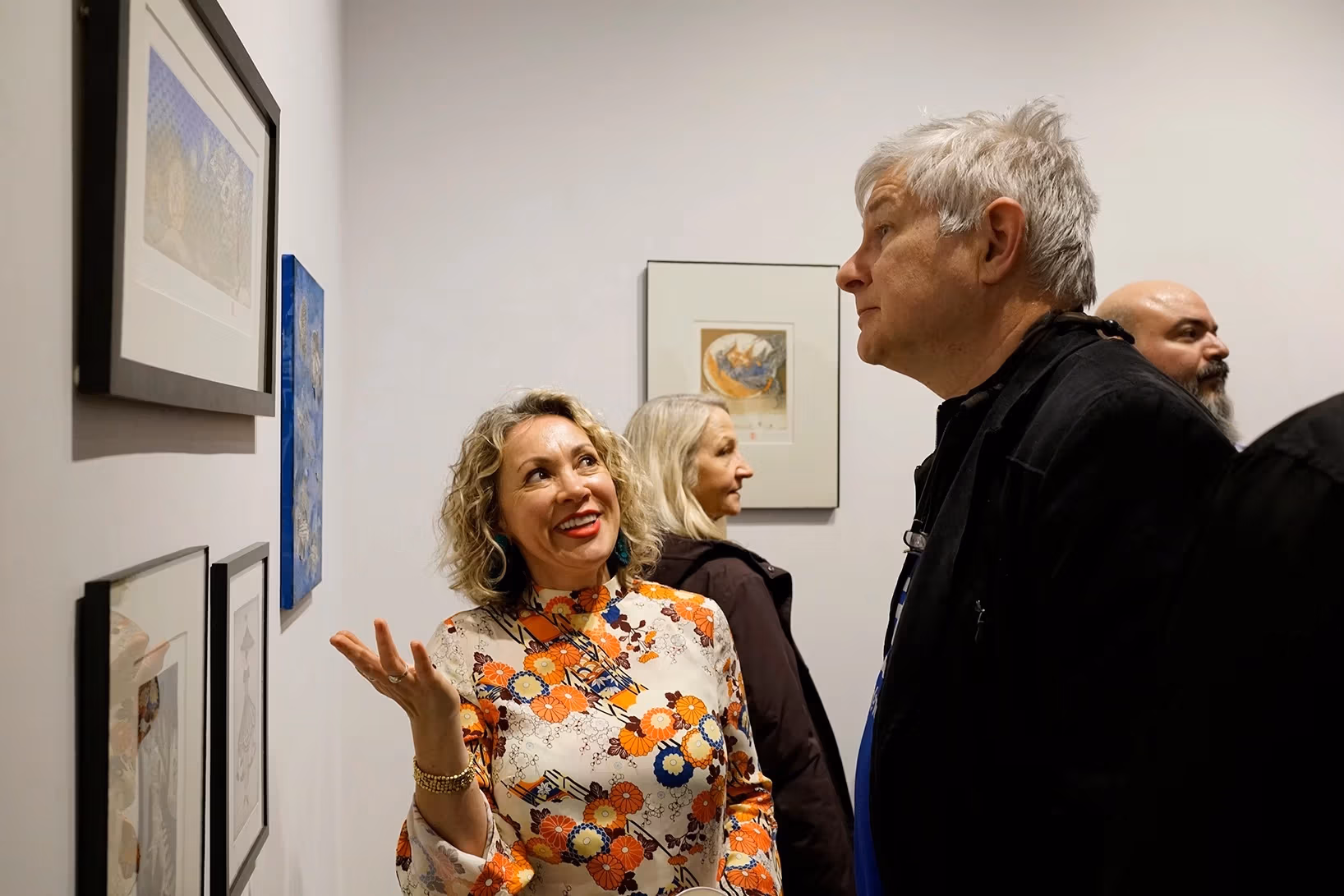 Artist talking about her work to an audience member.