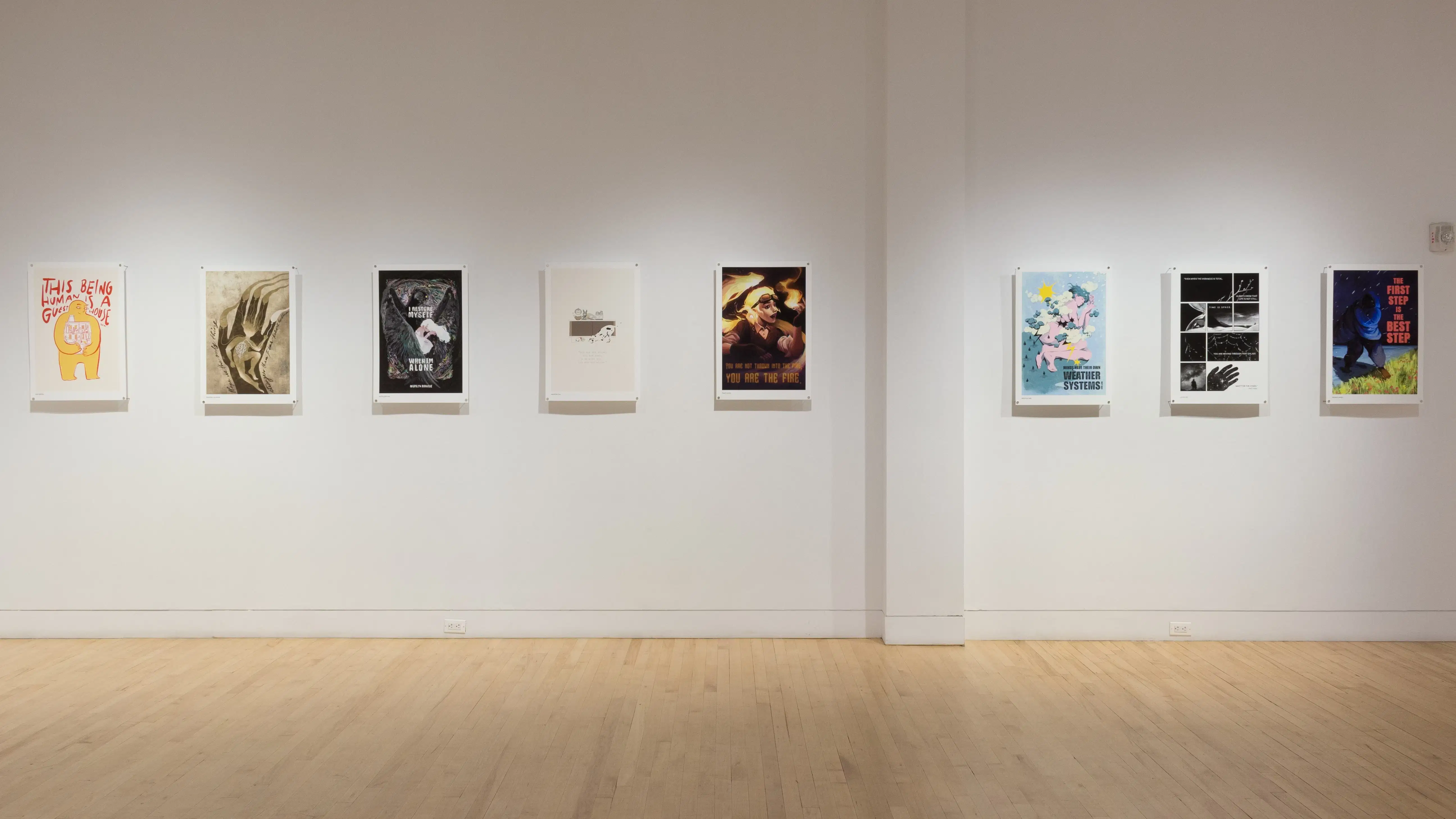 Eight poster illustrations hang in a row along the gallery wall. Some are in color and some in black and white.