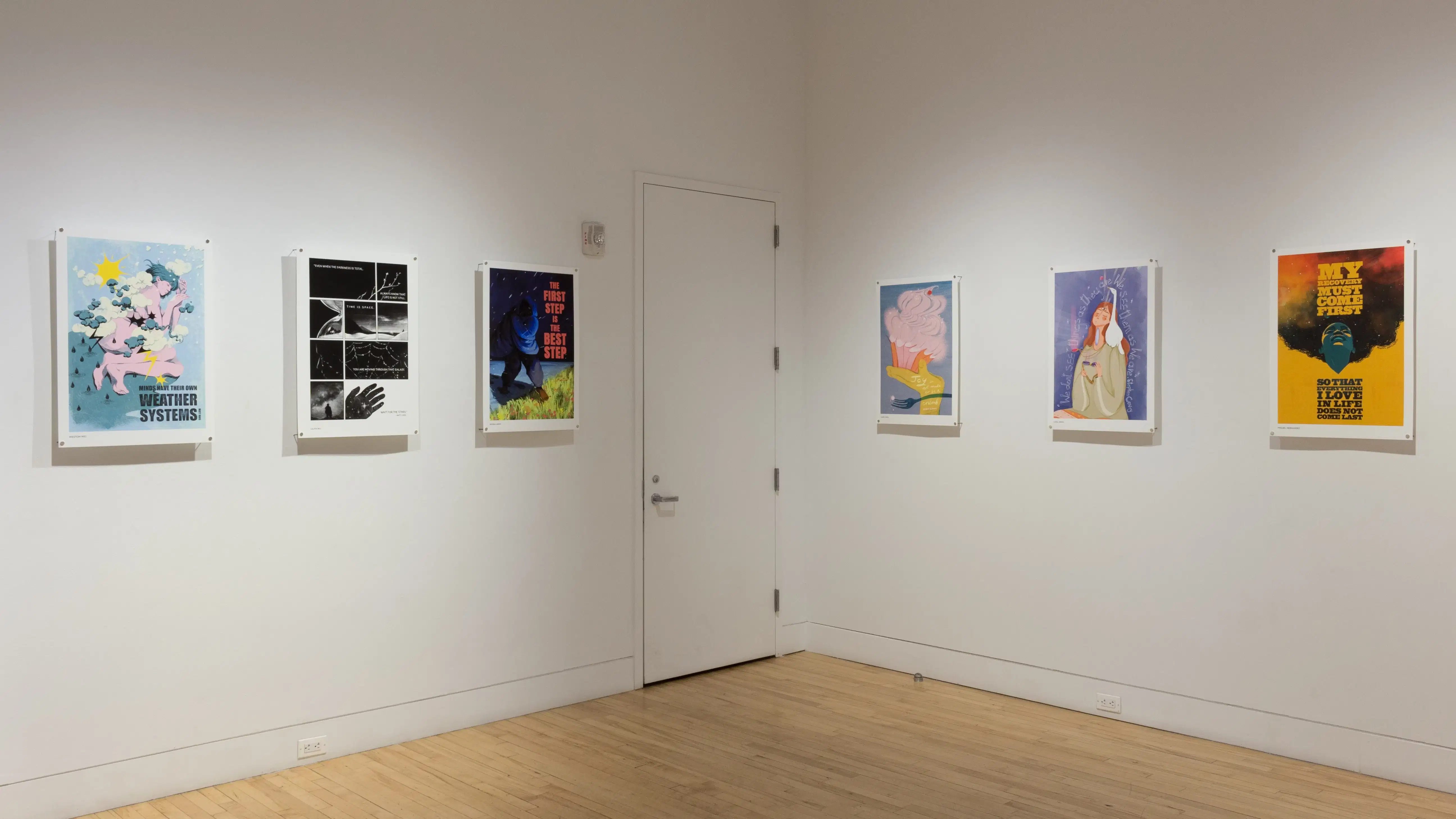 Six poster illustrations hang in a horizontal line along another corner wall in the gallery space, separated by a door. 