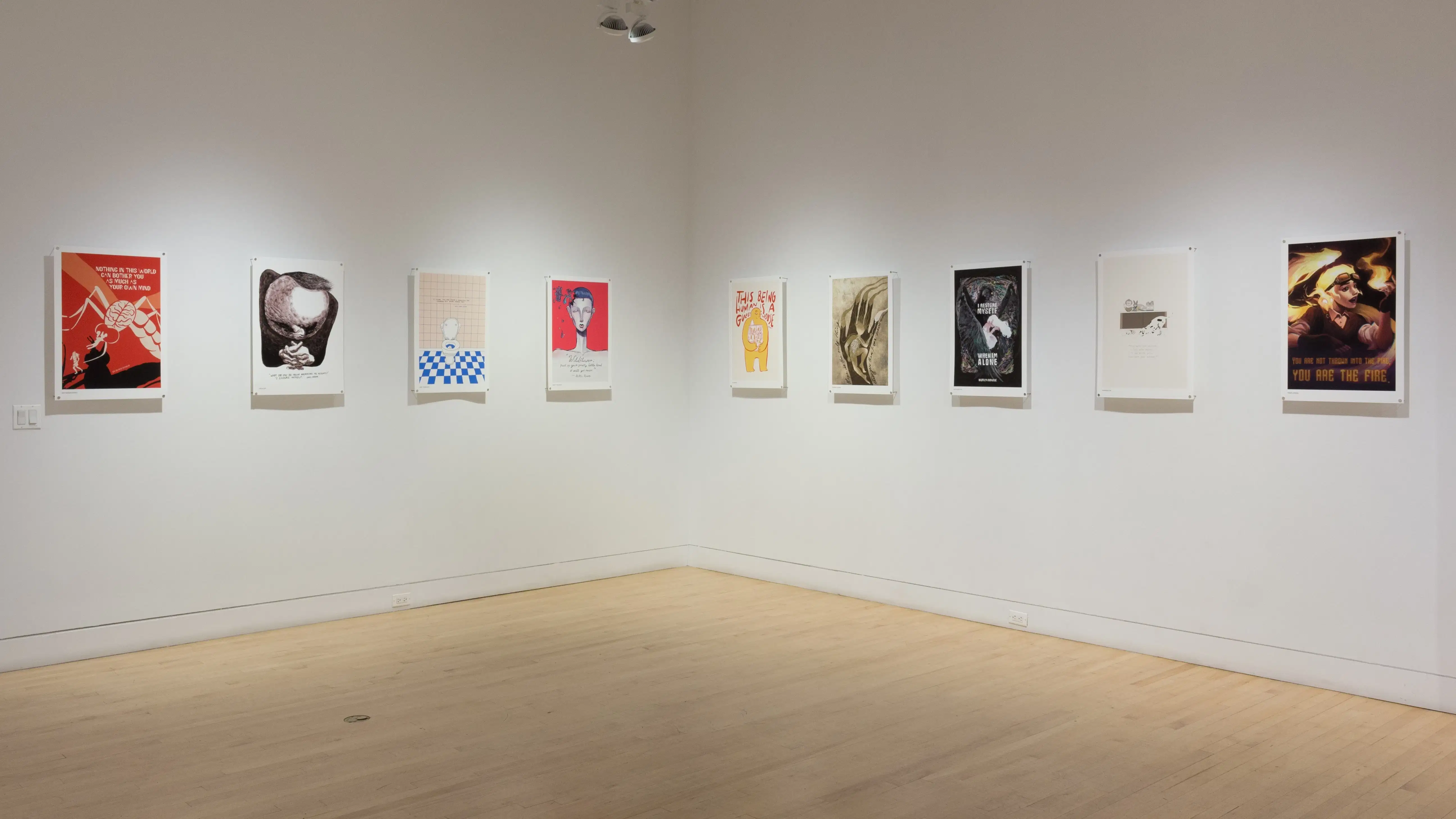 Colorful poster illustrations hang in a horizontal row along the middle of the gallery walls.