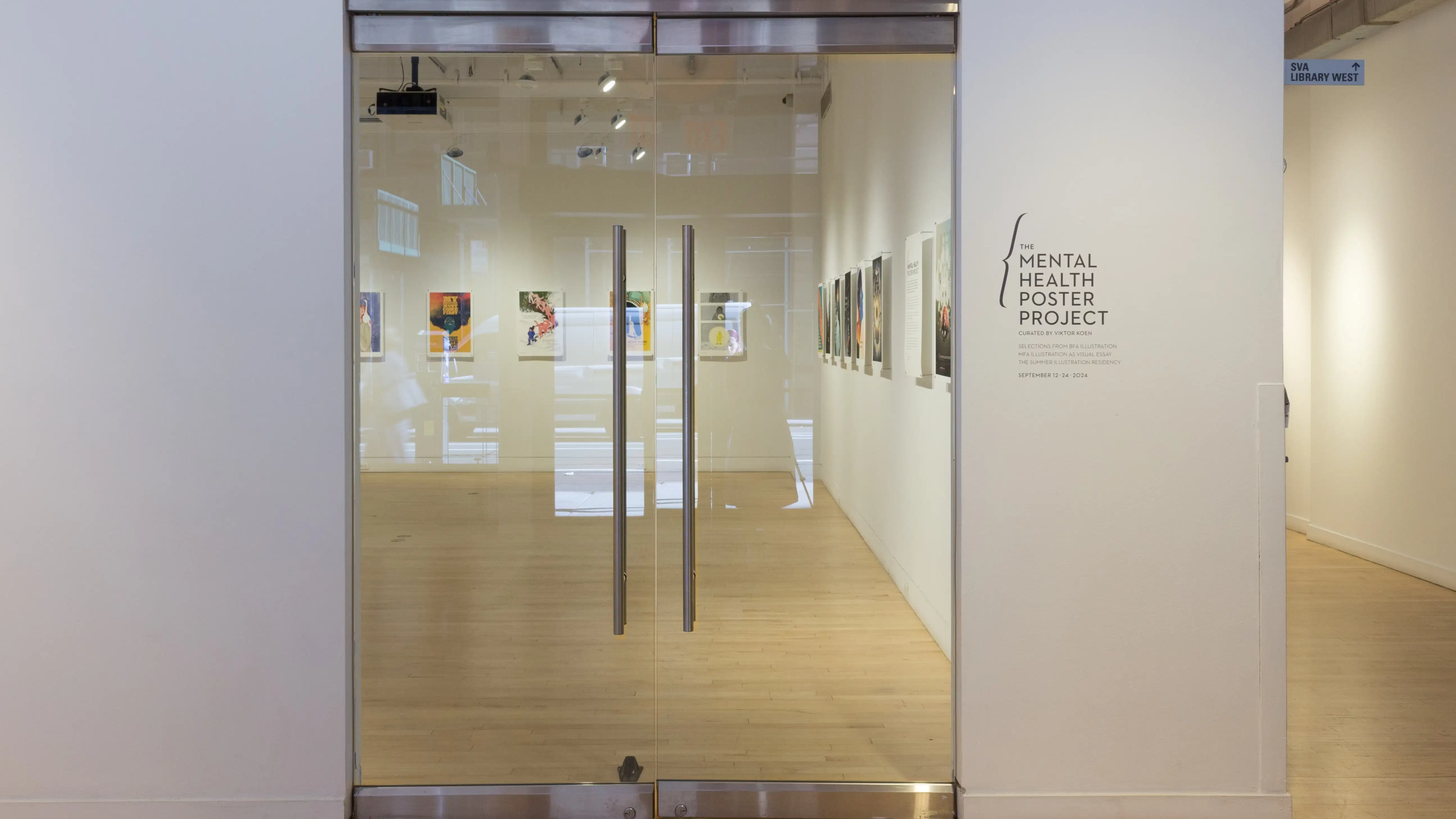 The entrance doors to SVA Flatiron gallery and black vinyl lettering that reads “The Mental Health Poster Project.” 
