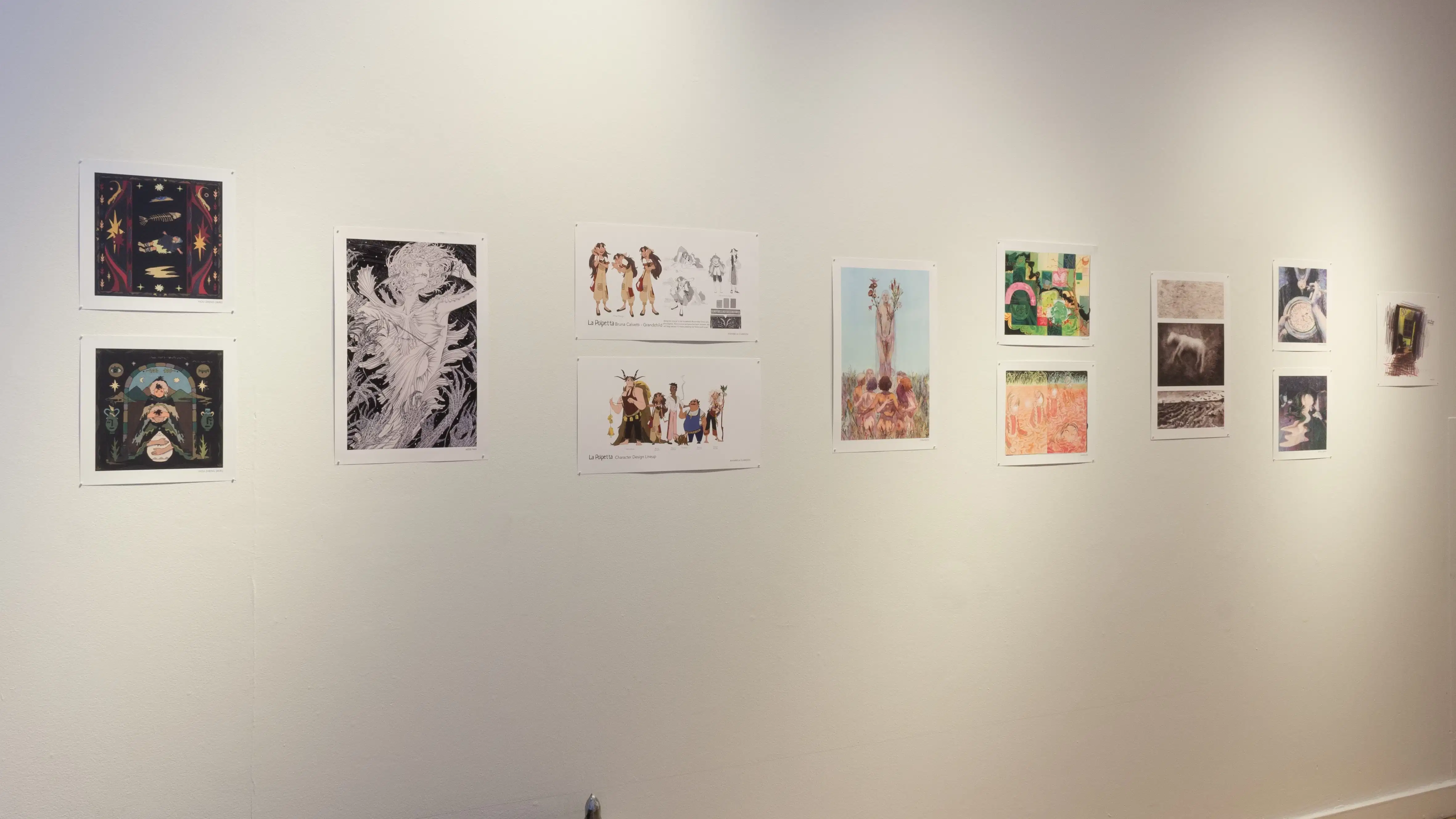 Illustrative prints hang in a horizontal two-to-one arrangement along the gallery wall.