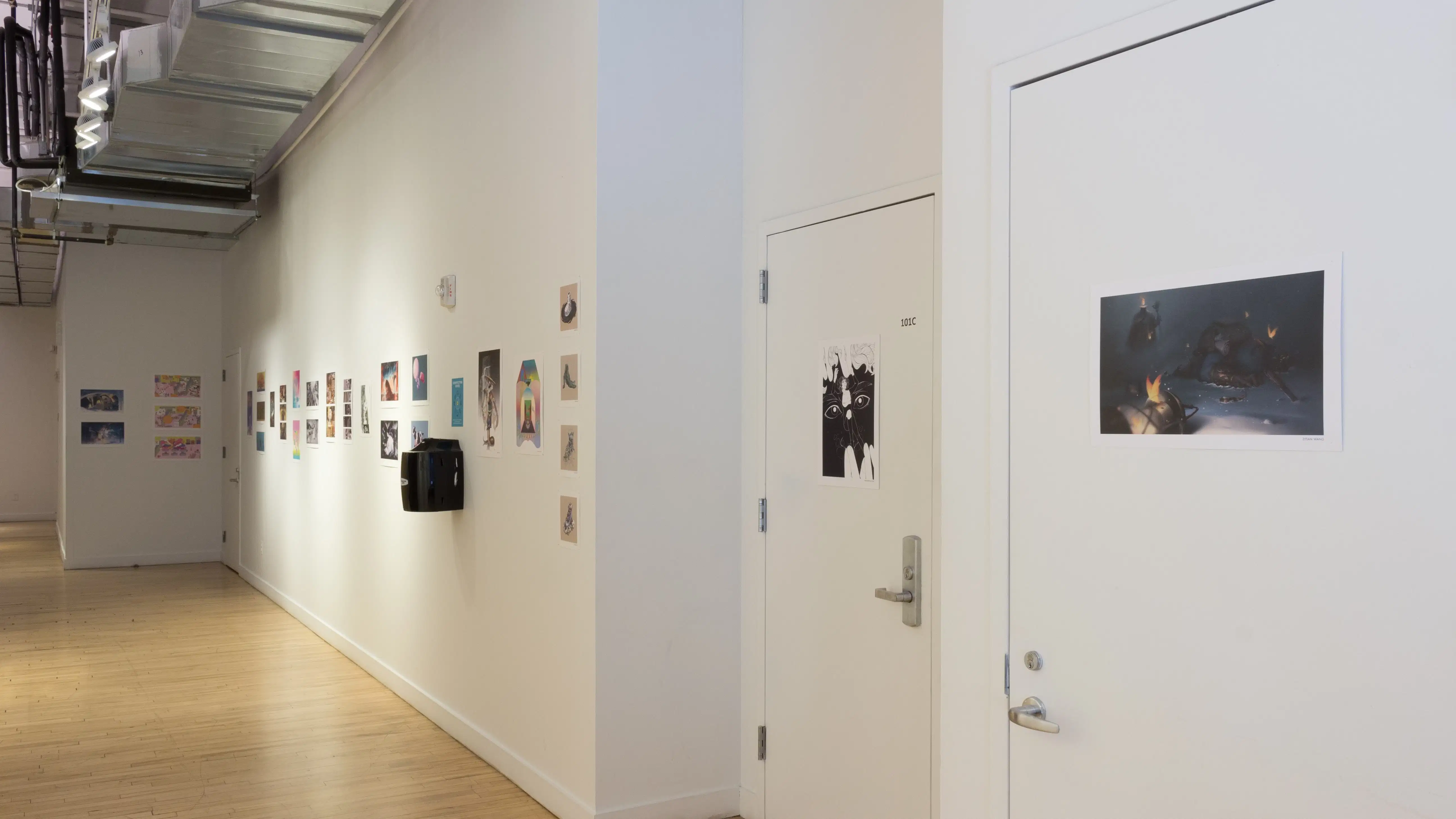 Illustrative prints hang on walls and doors outside of the SVA Flatiron Gallery space.