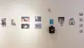 Eight illustrative posters hang along the gallery wall and four smaller illustrations are arranged in a vertical series.