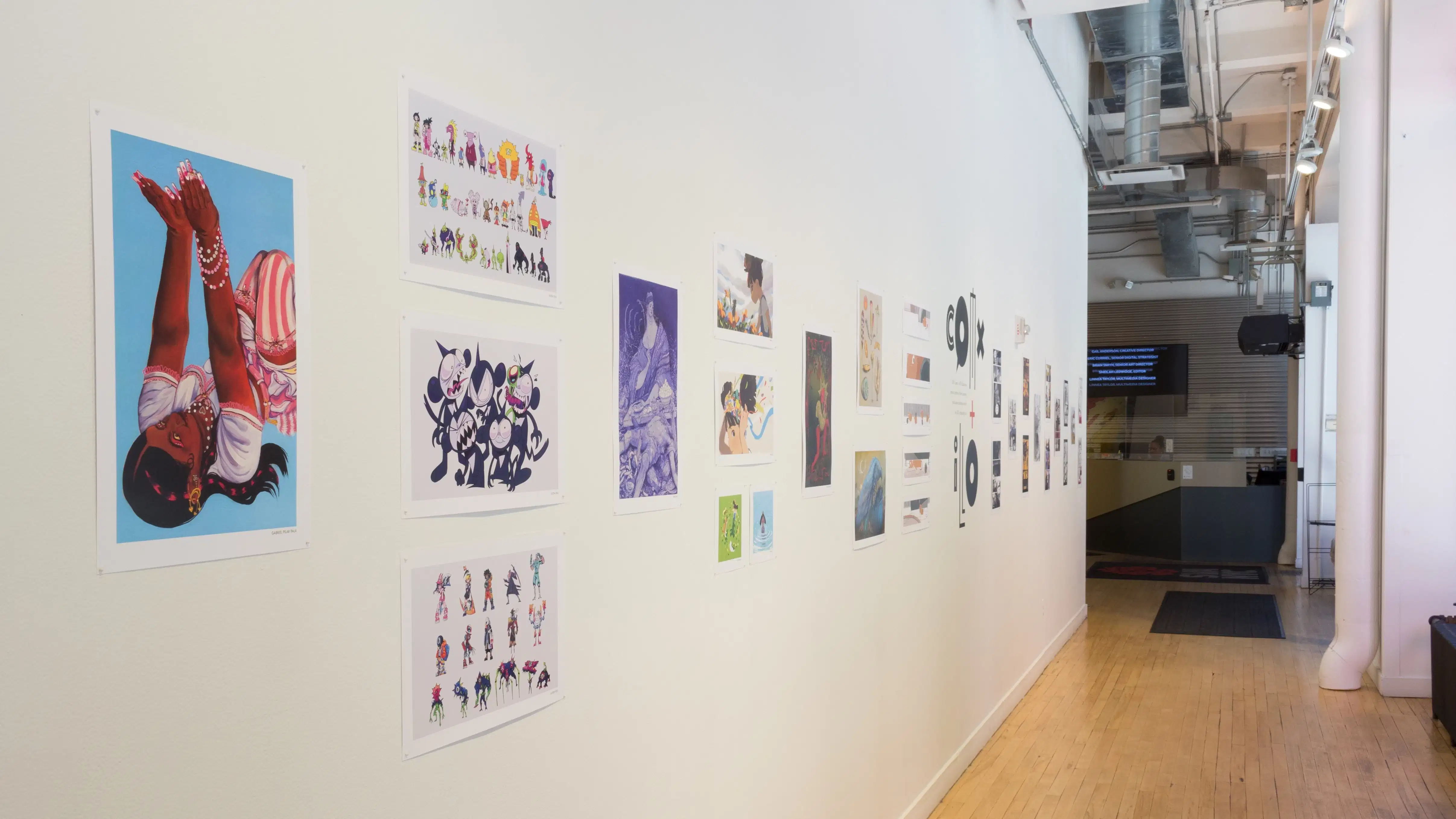 Illustrative prints hang in a row on the wall in the hallway outside of the SVA Flatiron Gallery.