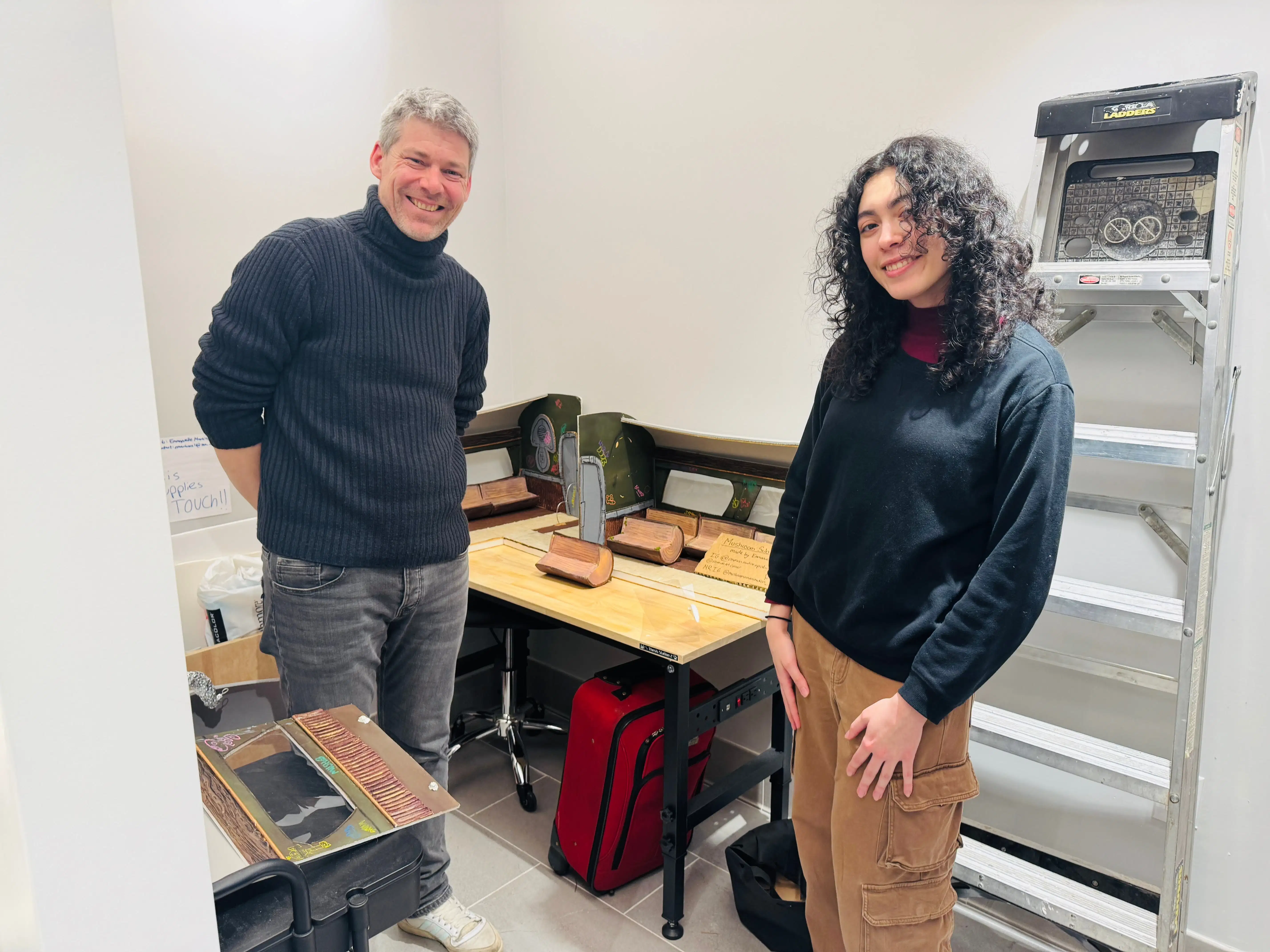[Left]:Four individuals are standing underneath a neon sign "Animation First." [Middle]:Two Individuals pose in front of a miniature building set design. [Right]: One individual sits at a computer desk as a second individual crouches beside them, observing the monitor.