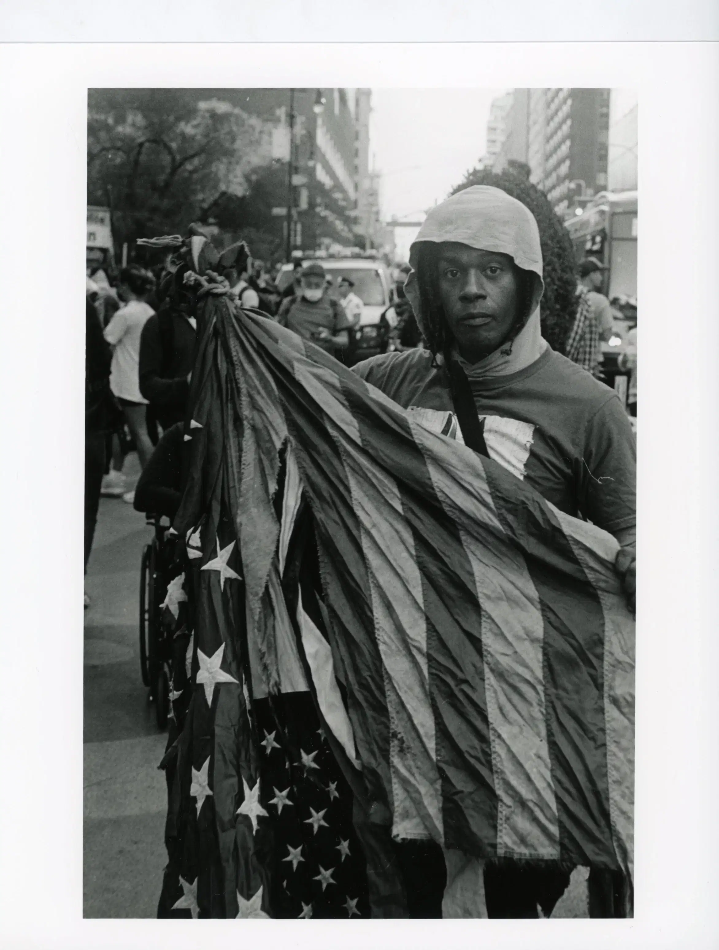Image taken during a Palestine protest, a man was holding an American flag in his hand.