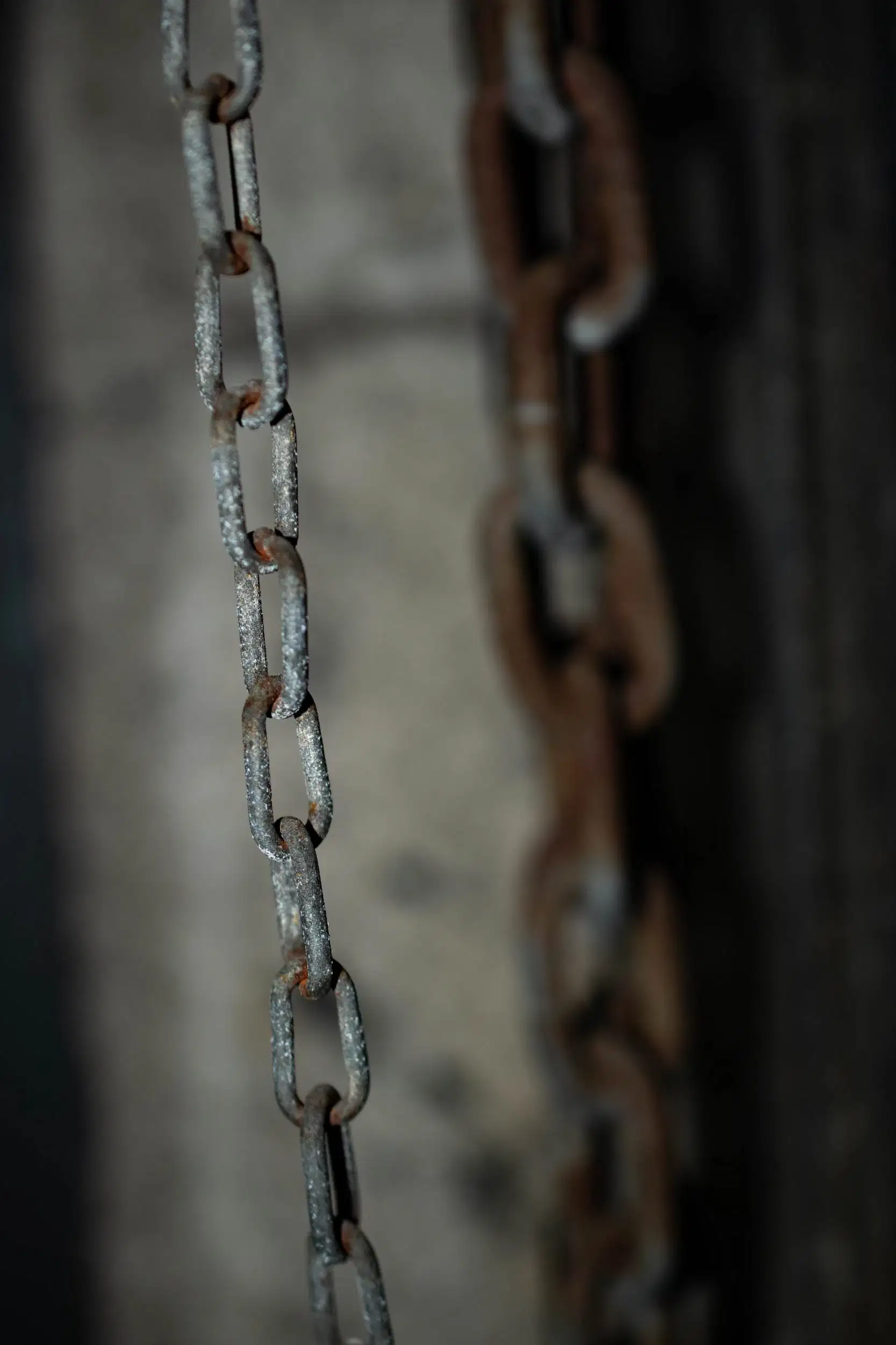 Close-up image of a rusted chain, with an out of focus chain in the background.