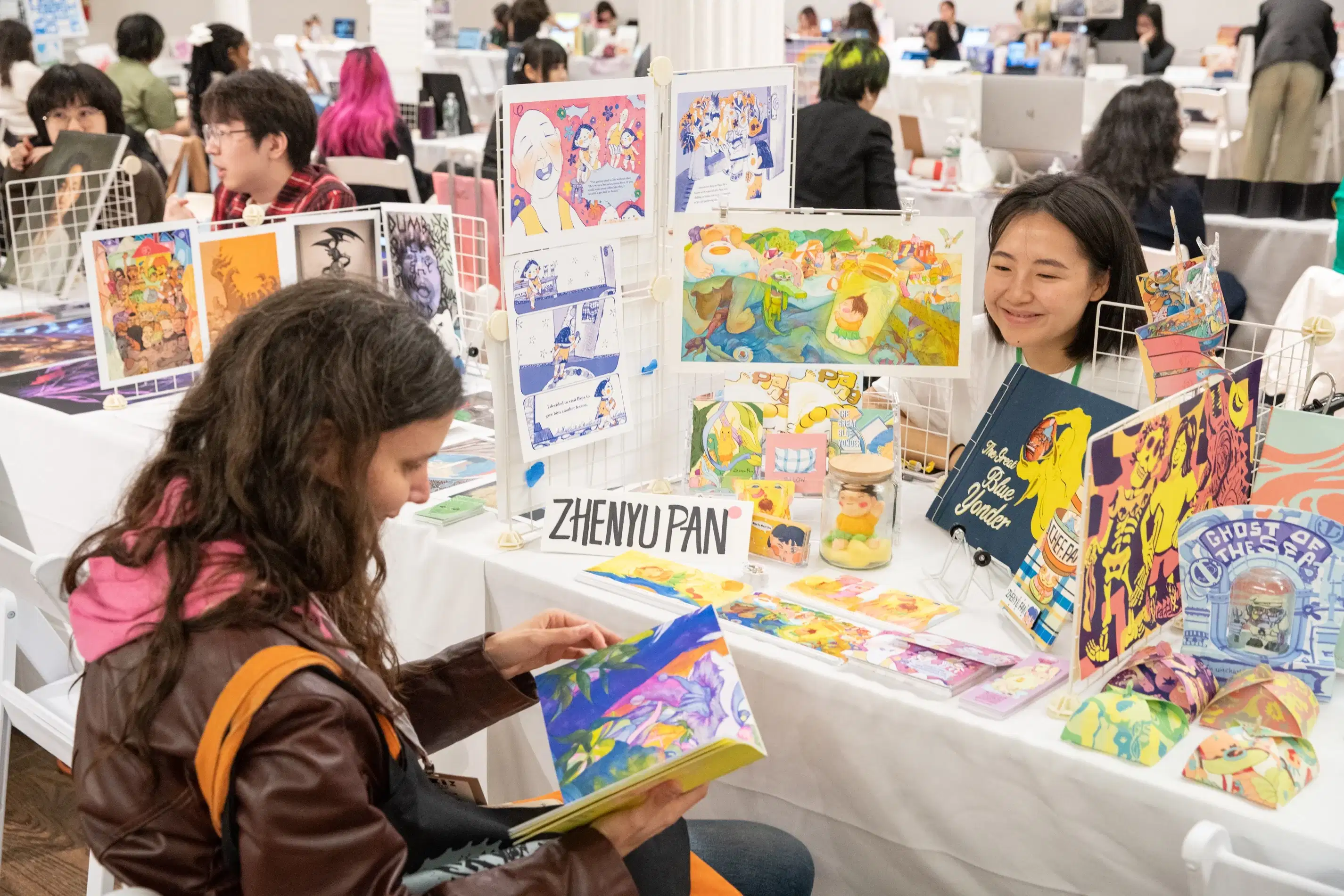 A student chats with a guest about their display of work.