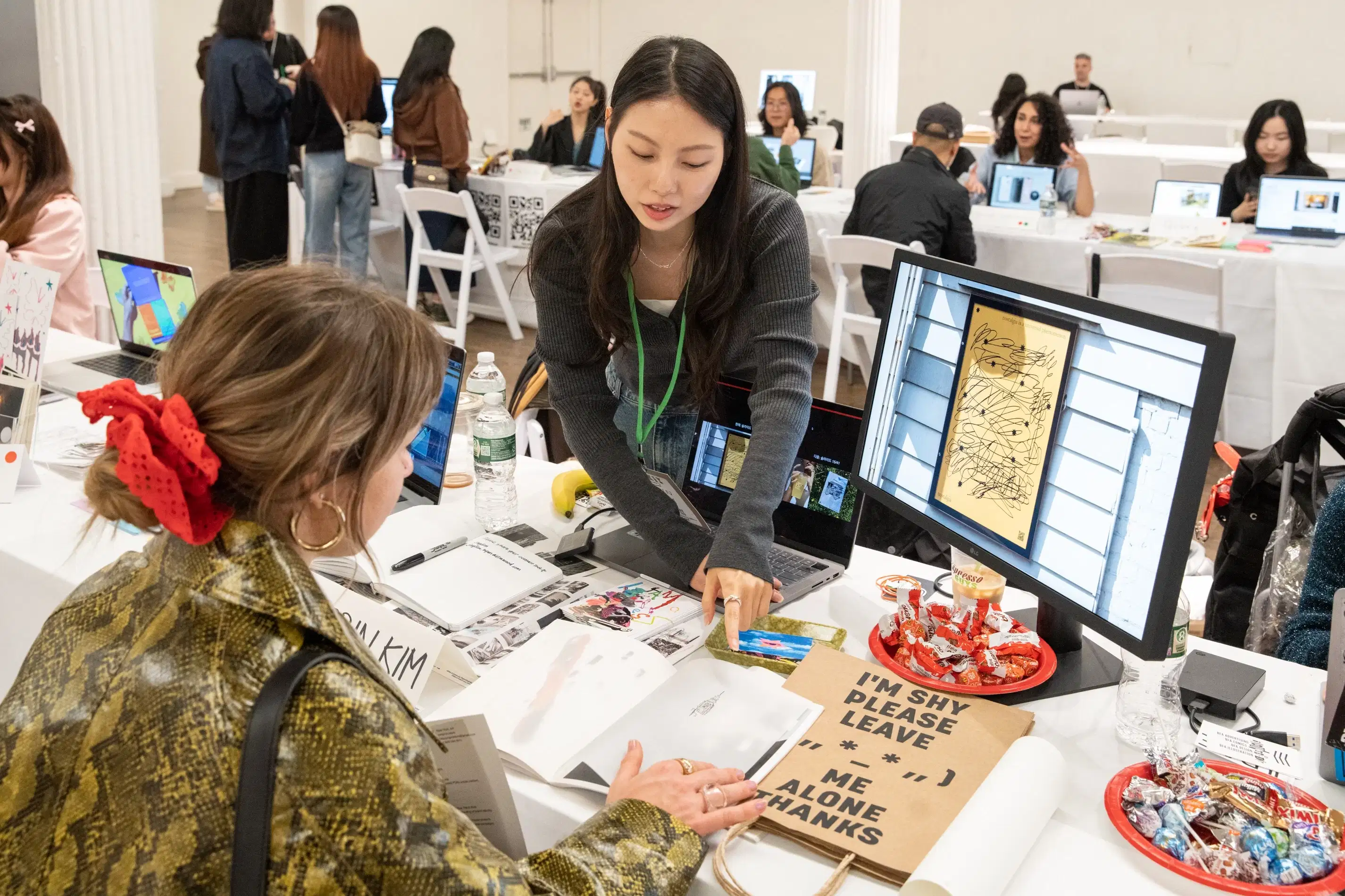 A student chats with a guest about their display of work.