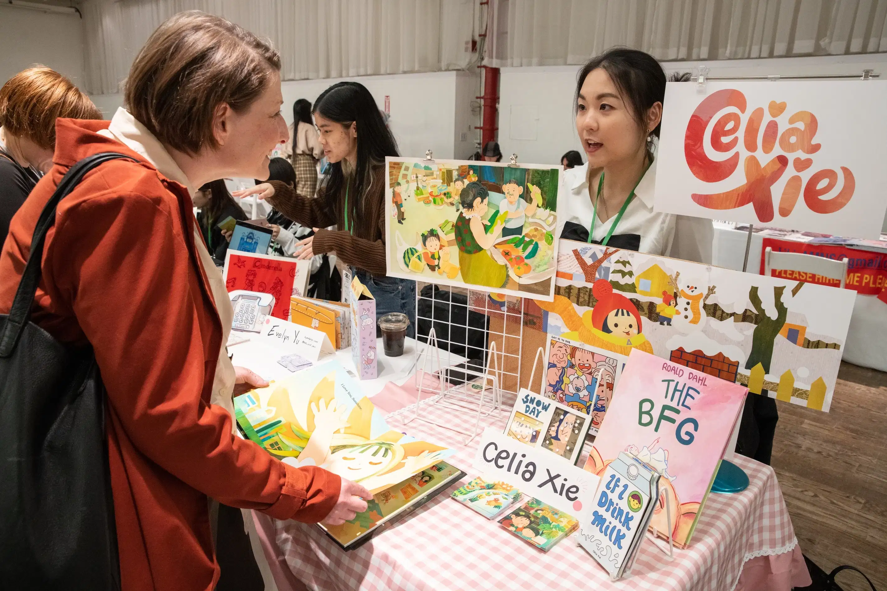 A student chats with a guest about their display of work.