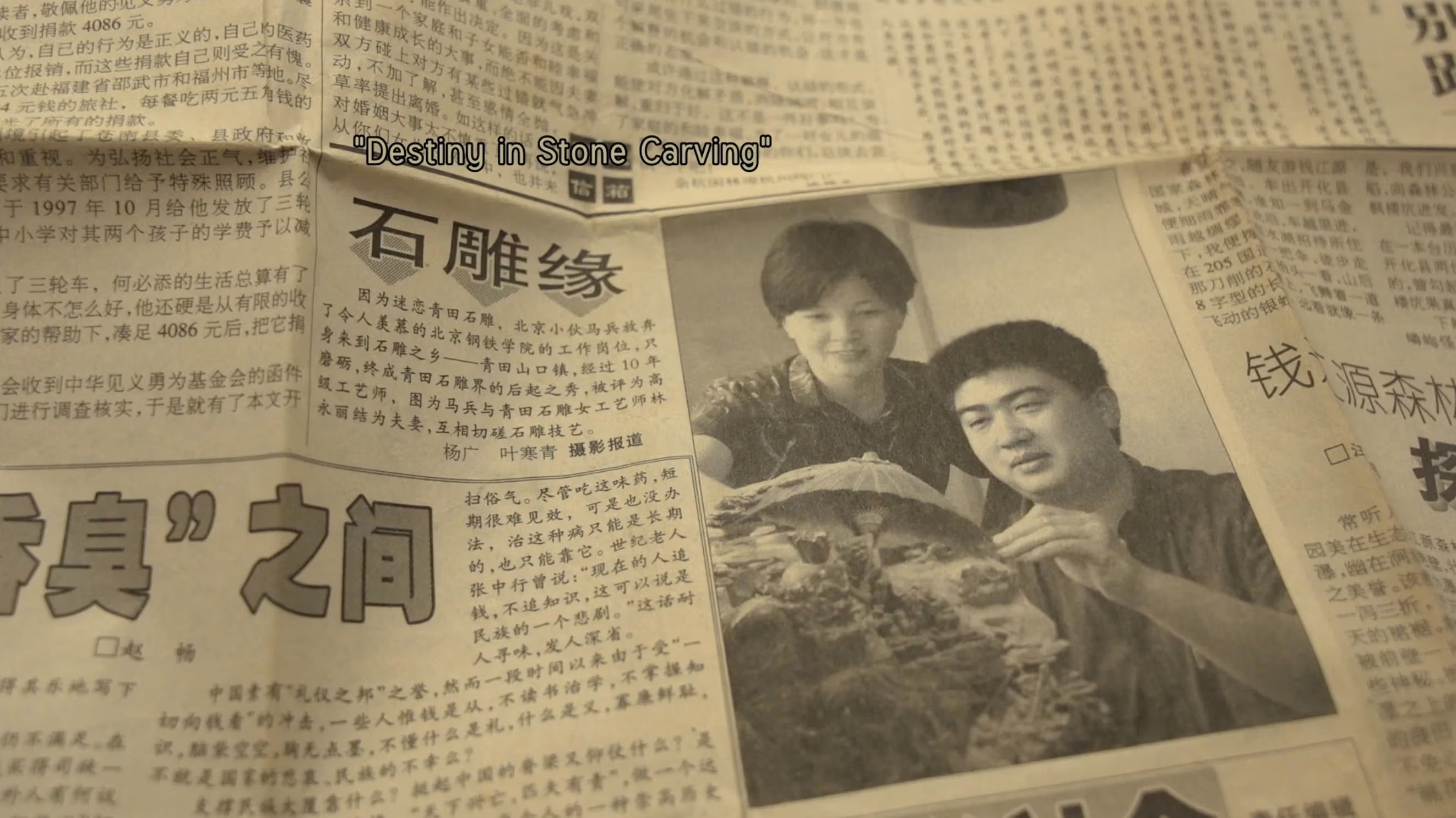 a Chinese newspaper with a black and white image of a young man and woman behind a stone carving, subtitle reads "Destiny In Stone Carving"
