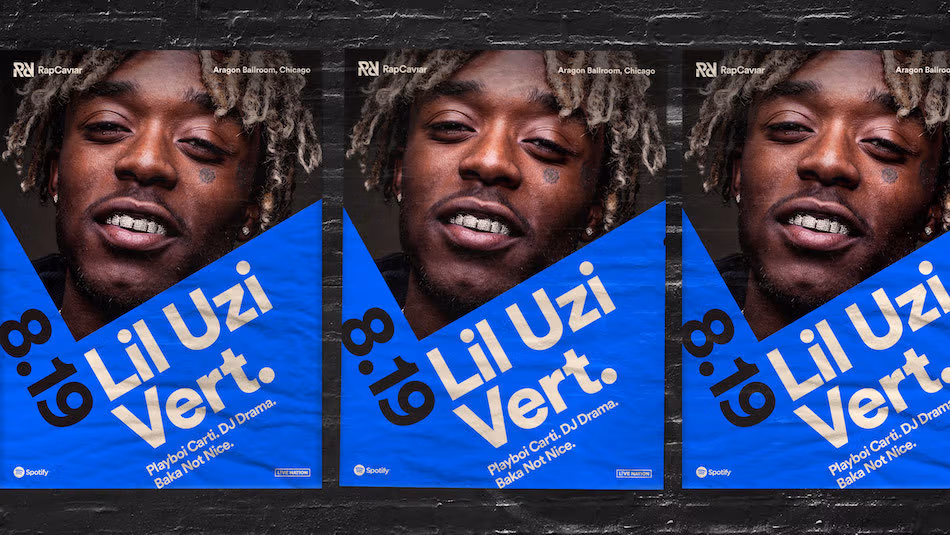 <p "="">A photograph of a brick wall plastered with three identical concert posters, which feature a photograph of rapper Lil Uzi Vert.