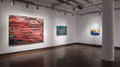 Exhibition photograph of “Between Picture and Viewer," showing paintings on two walls. On left is are two large abstract paintings in red and green, on the right is another abstract painting in white, yellow, brown, and blue.