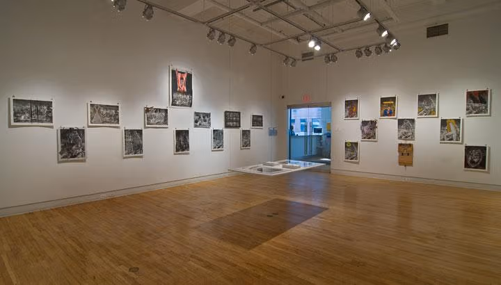 The image is an art gallery. The gallery has a hanging exhibit in the center.