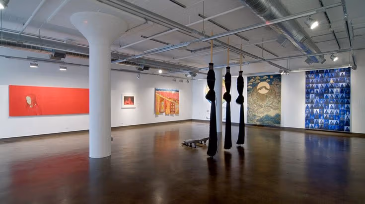 A gallery full of murals and a physical piece in the center.