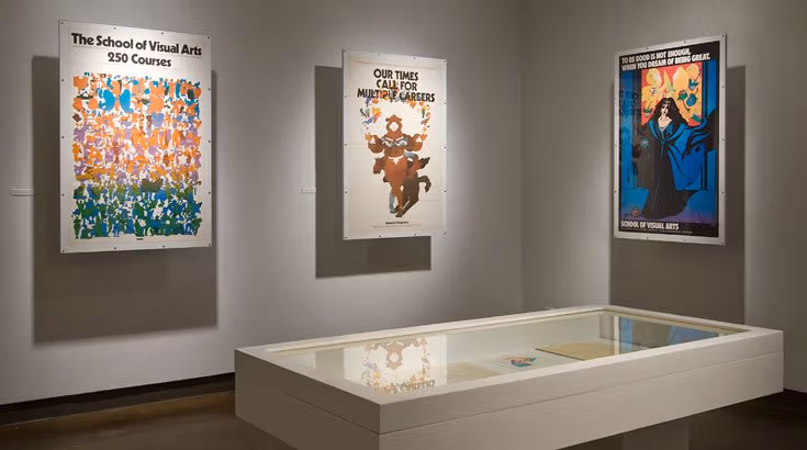 Several different posters displayed on the wall with a white rectangular table in the middle of the room